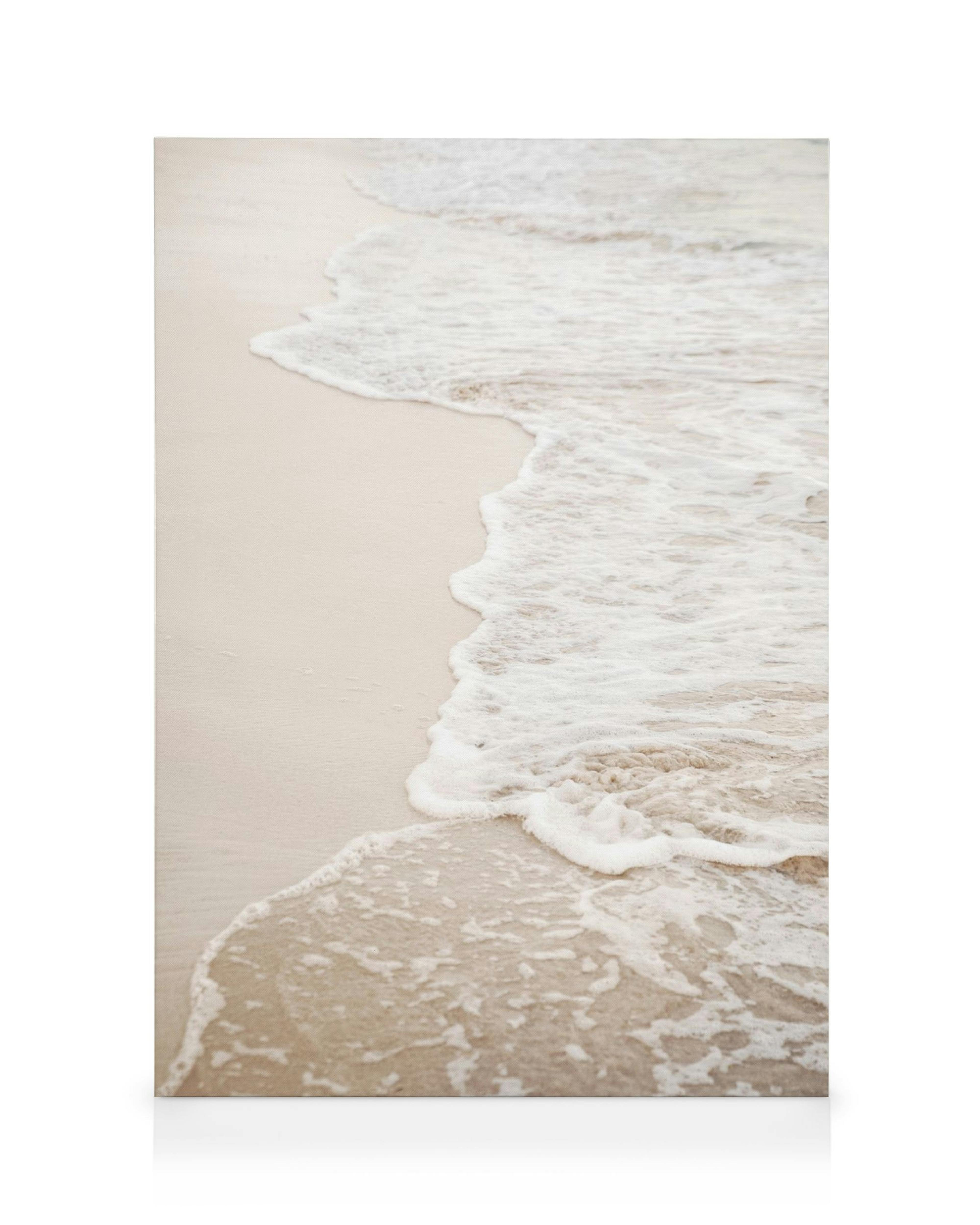 Toile de plage avec sable beige et vagues blanches pour une décoration murale