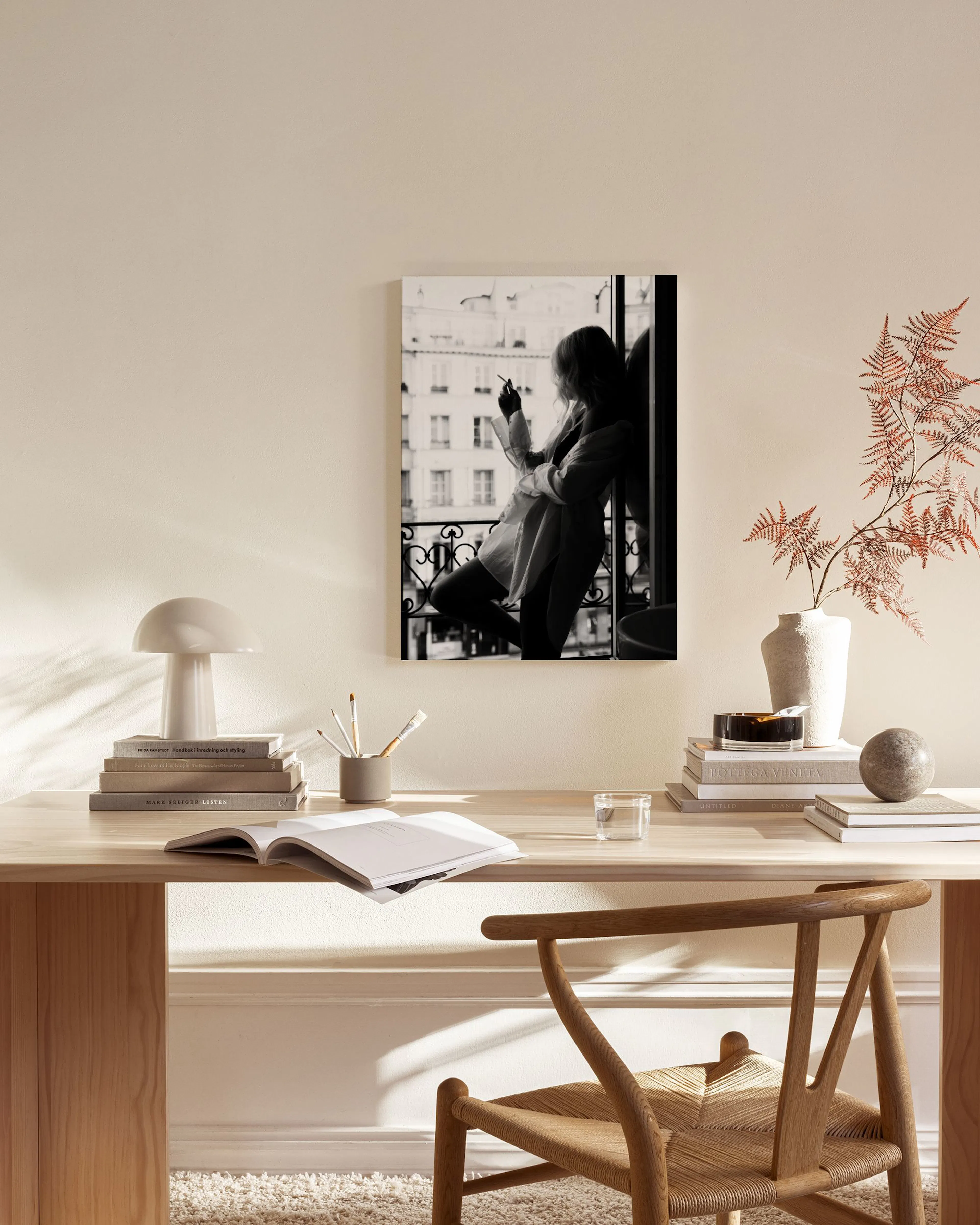 Schwarz-weiß Leinwandbild einer Frau auf einem Balkon, hängend im stilvollen Wohnzimmer über einem Sideboard.