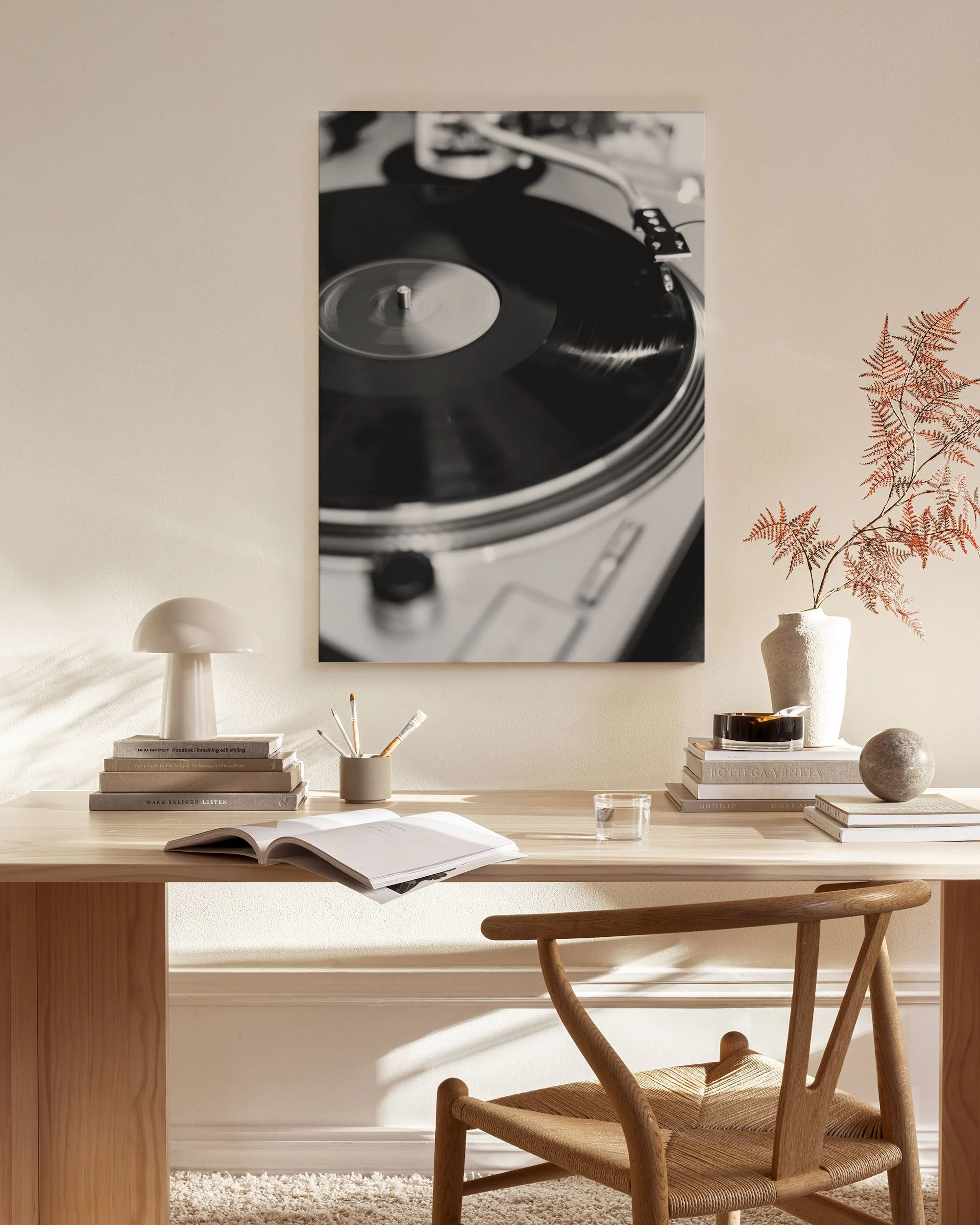Toile murale noir et blanc dune platine vinyle, affichée au-dessus dun banc en bois dans un salon moderne.