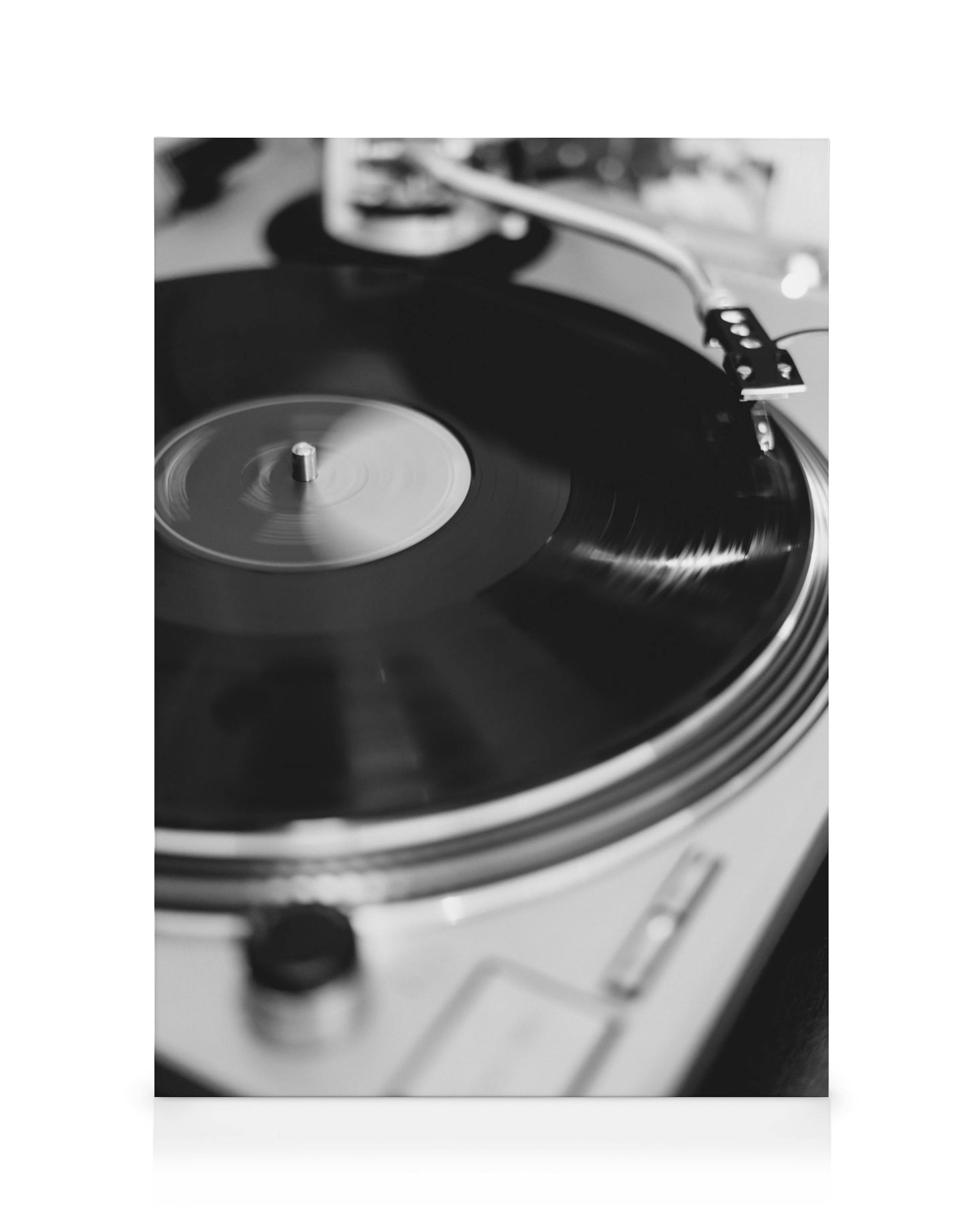 Toile noire et blanche dun disque vinyle tournant sur une platine, avec un effet de mouvement pour le disque.