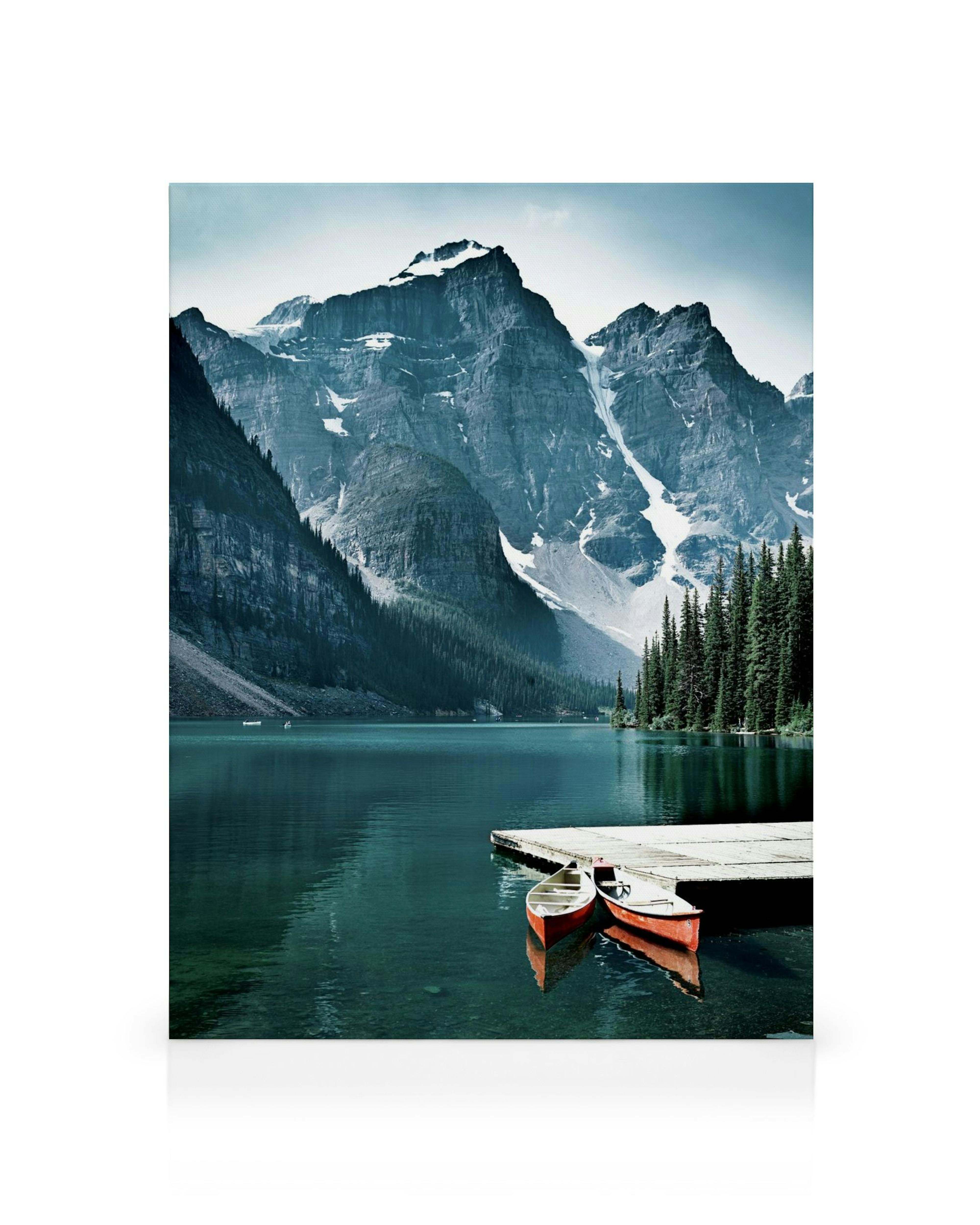 Obraz na plátne s jazerom, červenými kanoe pri móle a horami v pozadí.