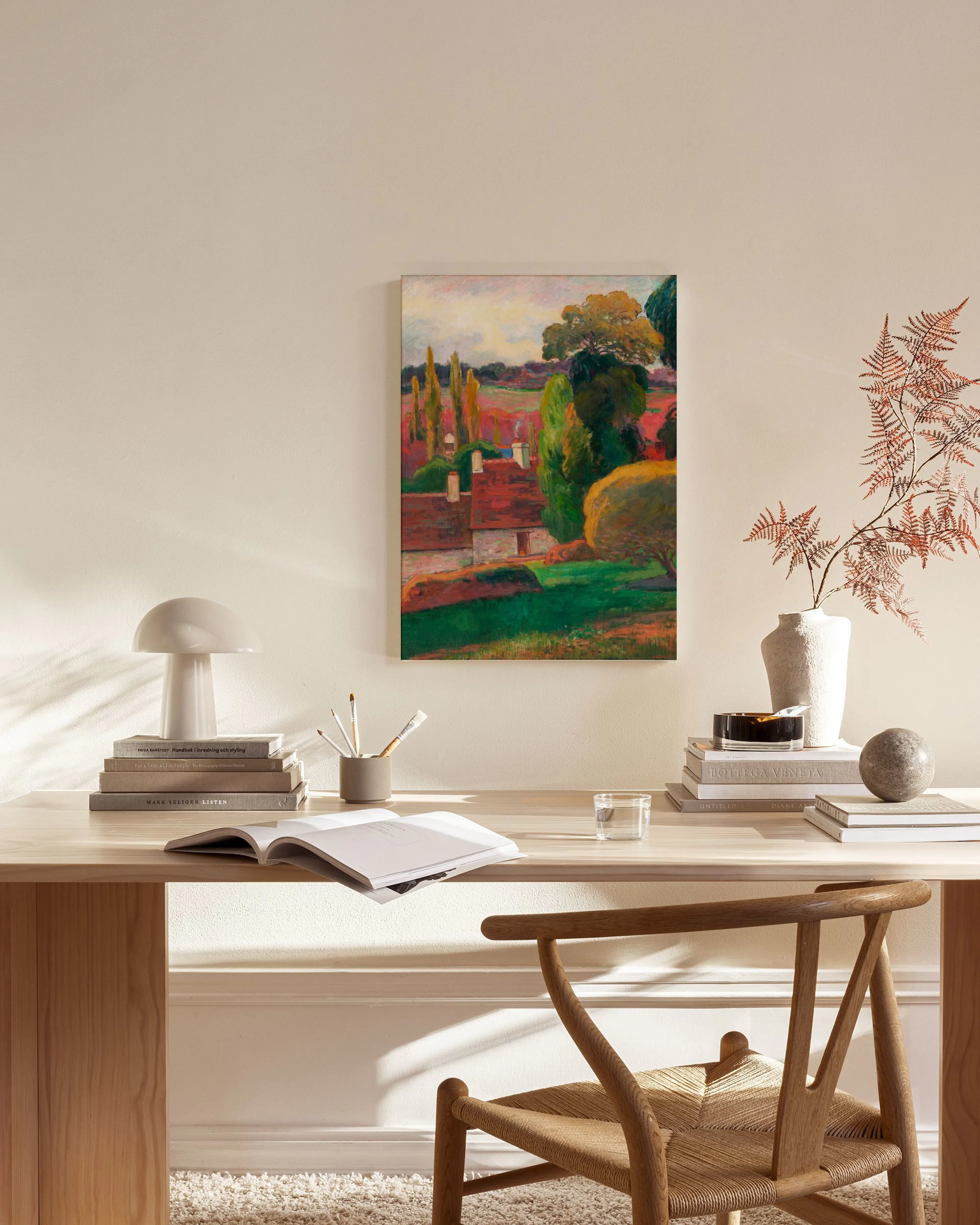 Stampa su tela di un paesaggio colorato con case, alberi e un cielo nuvoloso, appesa in un soggiorno moderno.