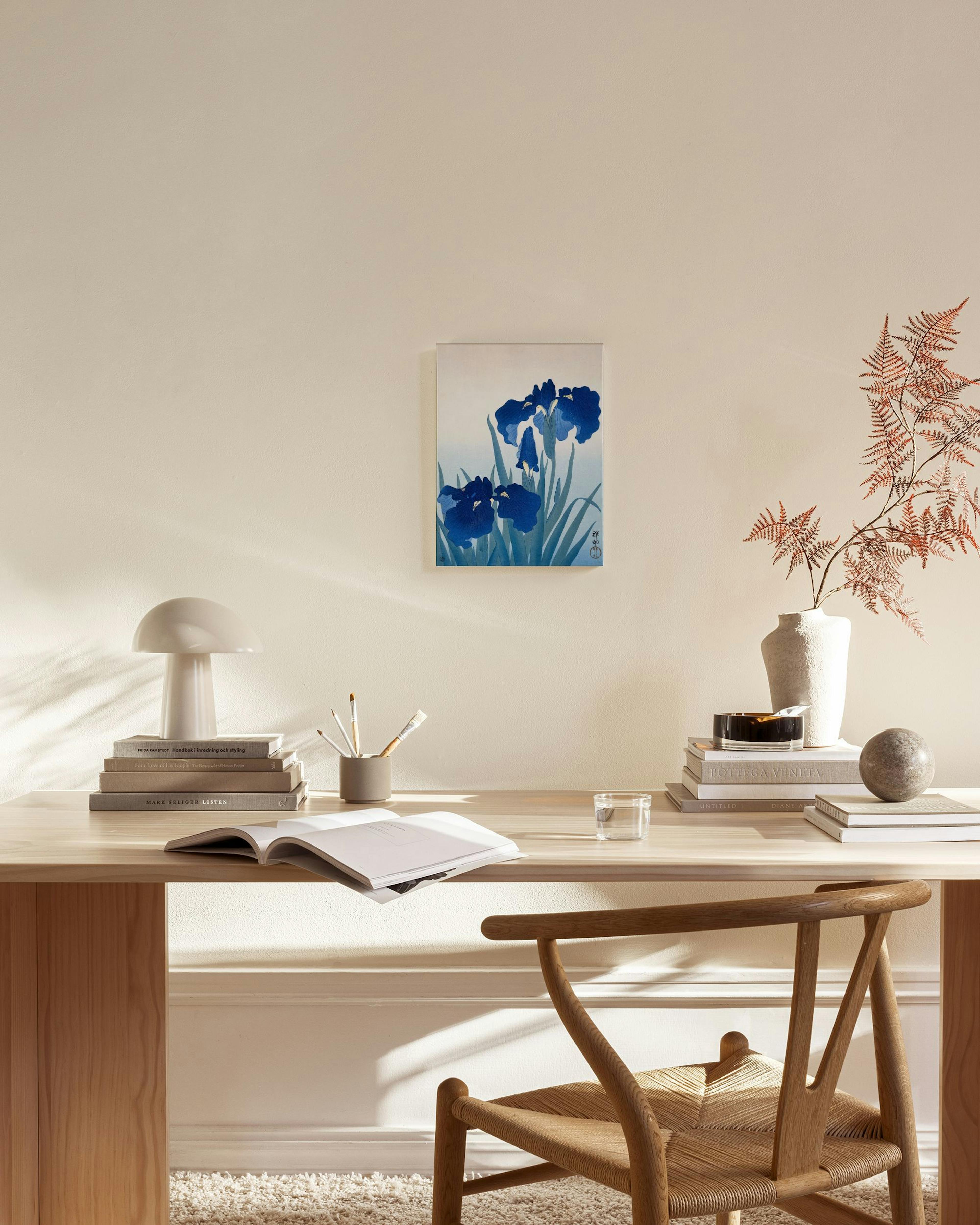 Toile murale décorative diris bleus dans un style japonais, accrochée dans un salon lumineux au-dessus dun banc en bois.