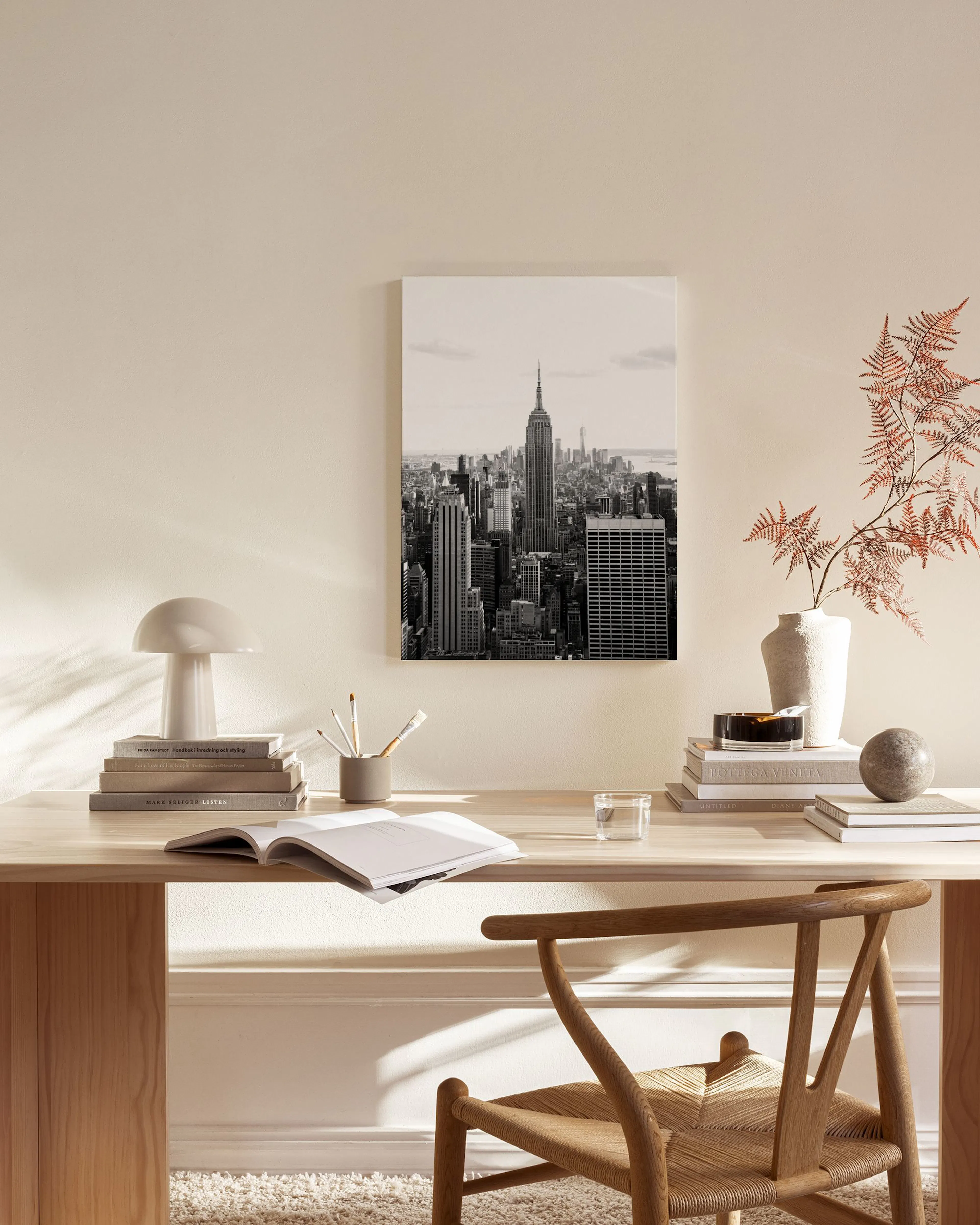 Stampa su tela in bianco e nero dello skyline di New York, appesa sopra una panca in un soggiorno moderno.