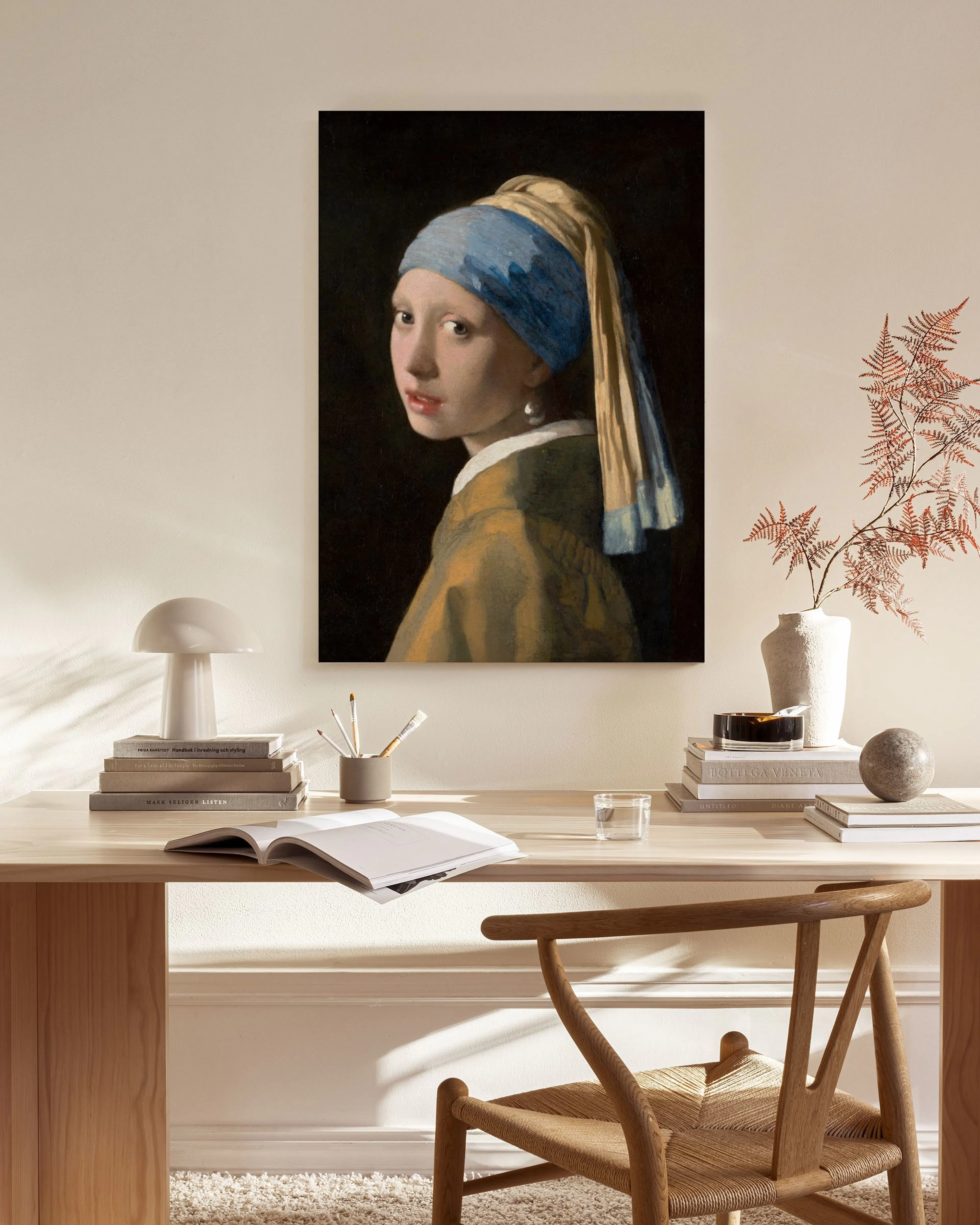 Leinwandbild des Gemäldes Das Mädchen mit dem Perlenohrring von Vermeer in einem modernen Wohnzimmer über einem Sideboard.