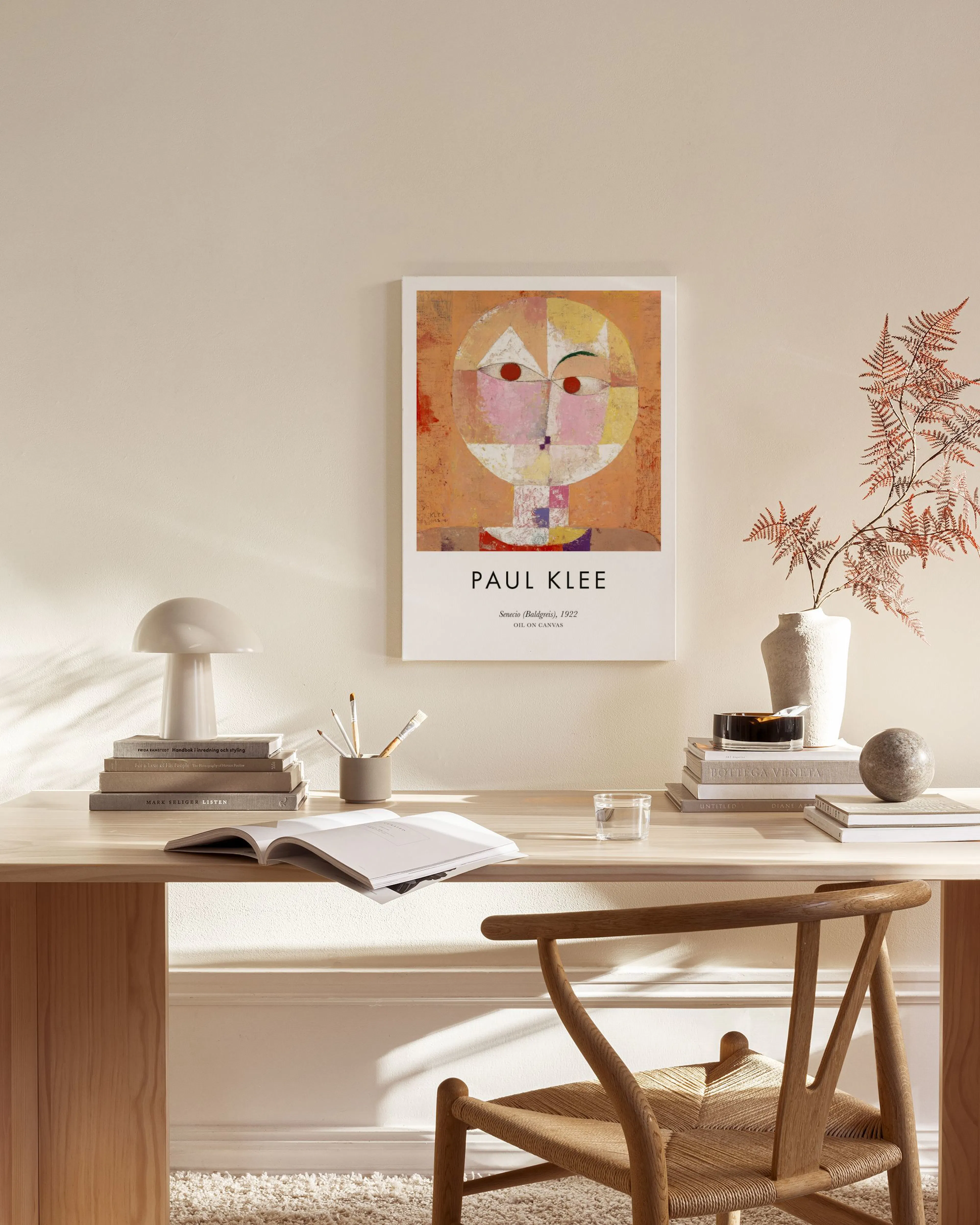 Leinwandbild Senecio (Baldgreis) von Paul Klee mit abstraktem Gesicht, hängt in einem modernen Wohnzimmer über einem Sideboard.