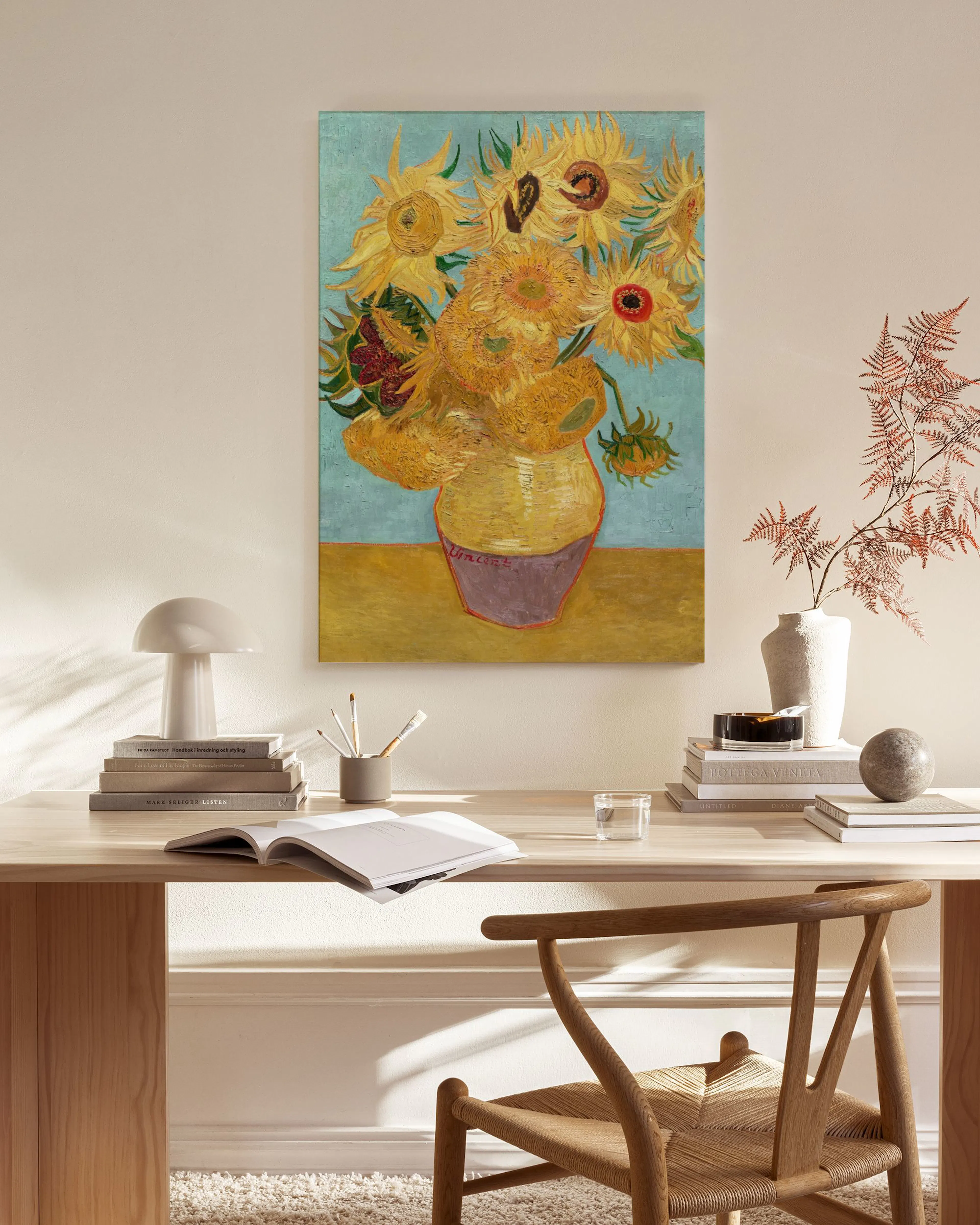 Canvas van Van Goghs zonnebloemen in een vaas, hangend in een lichte woonkamer boven een houten dressoir.