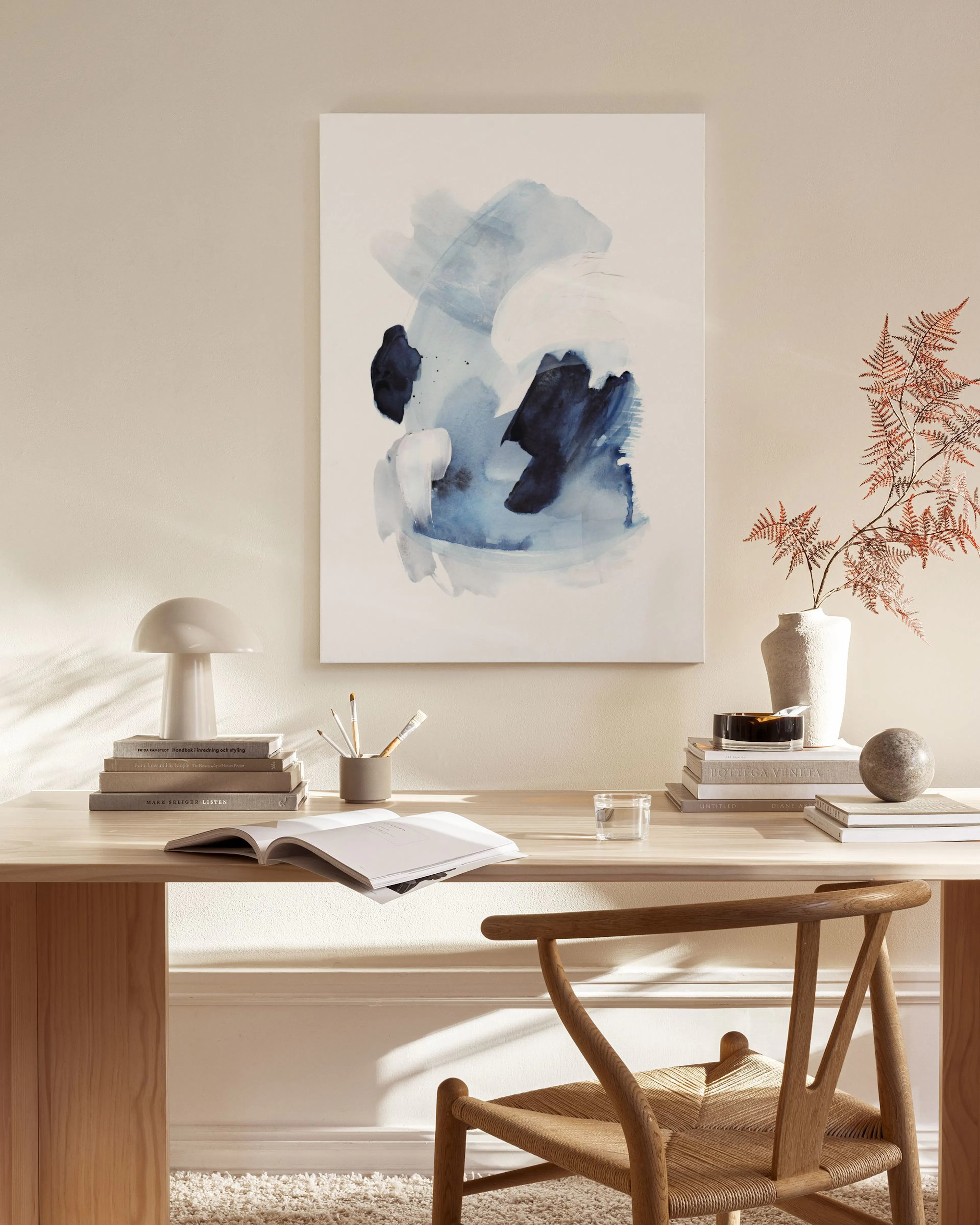 Abstract blue and white brushstroke canvas print displayed in a modern Australian living room above a wooden console.