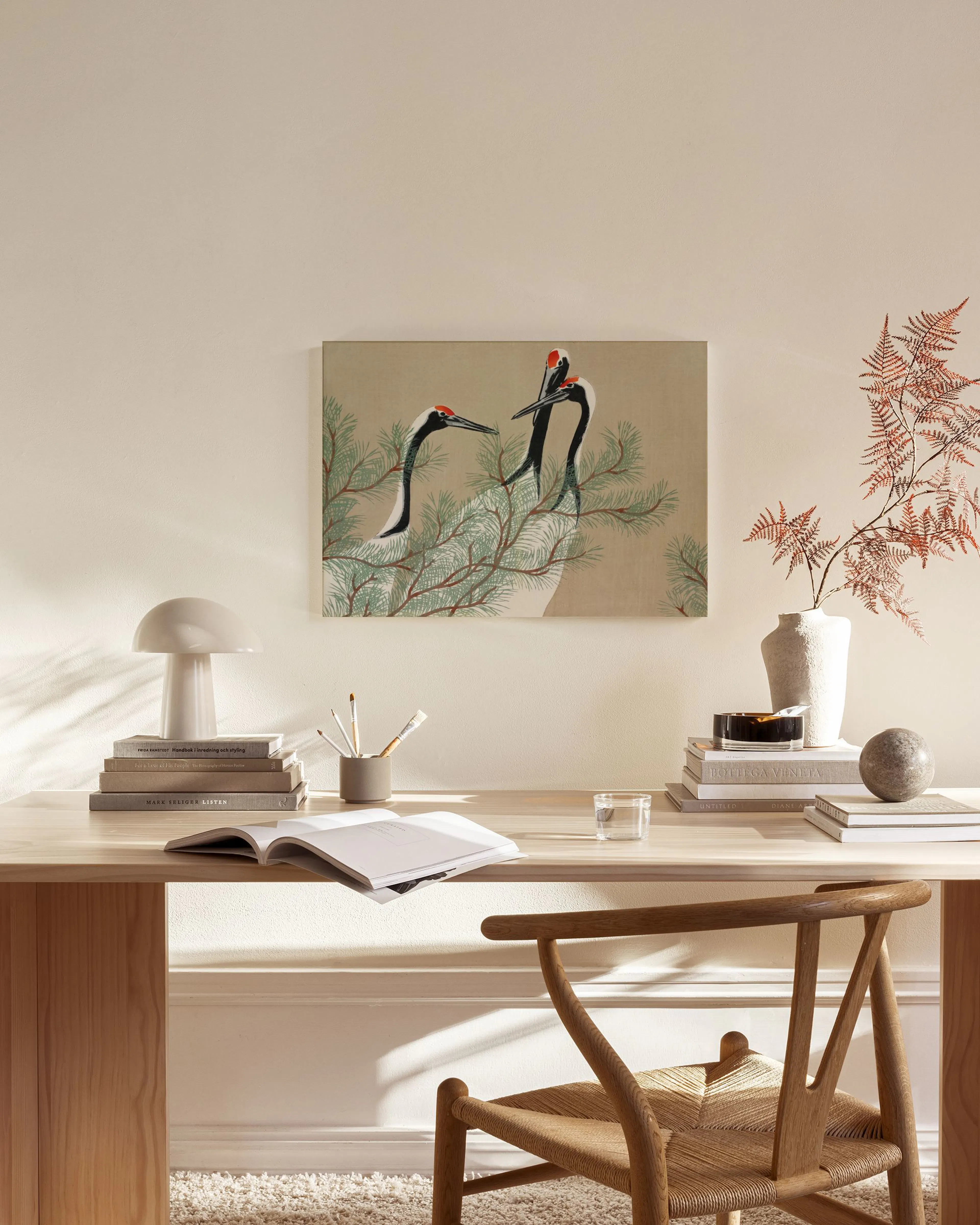 Leinwandbild mit zwei Kranichen im Nadelbaum, hängend über einem Sideboard in einem modernen Wohnzimmer.