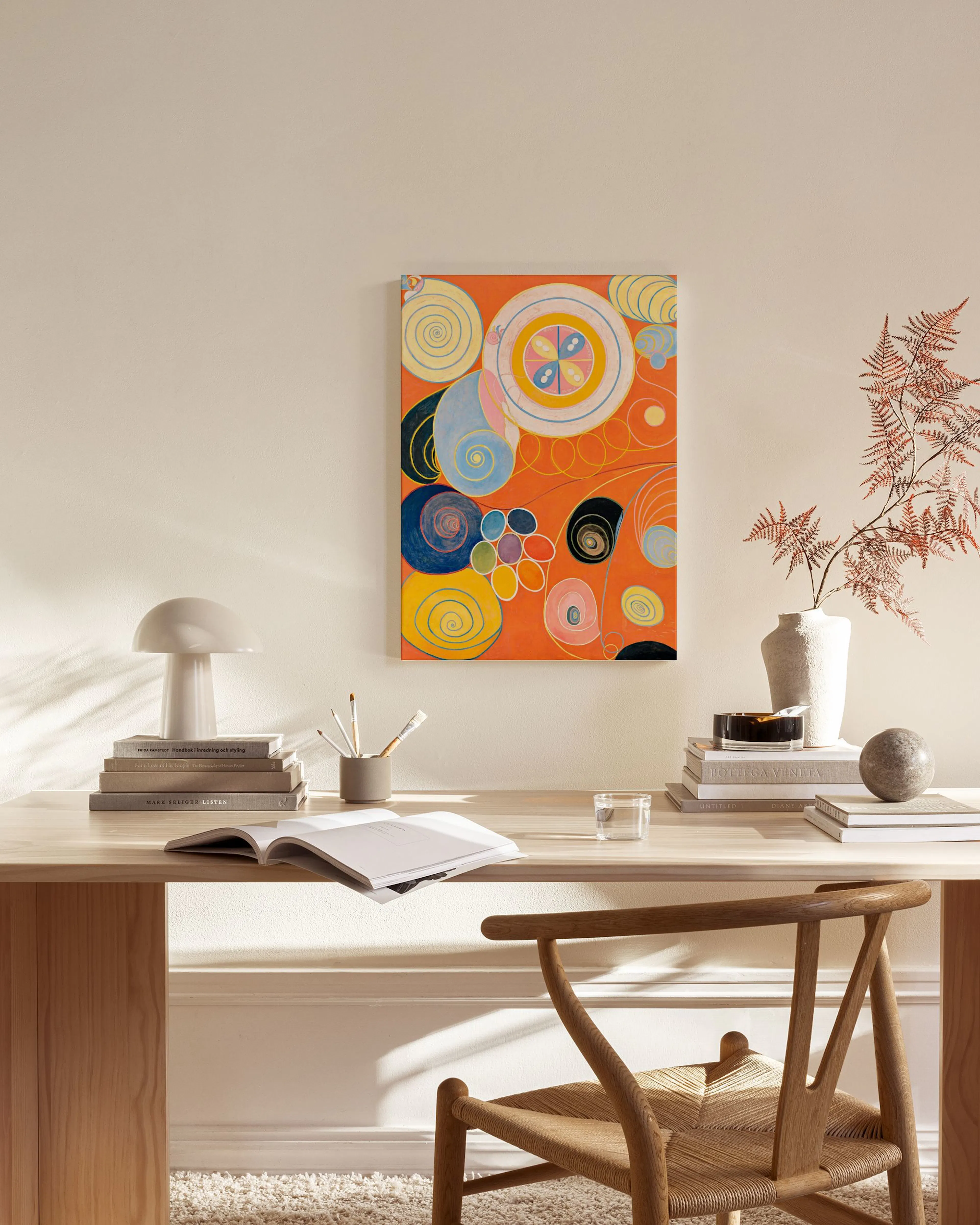 Abstraktes Leinwandbild mit bunten Kreisen und Spiralen auf orangefarbenem Hintergrund, in einem modernen Wohnzimmer.