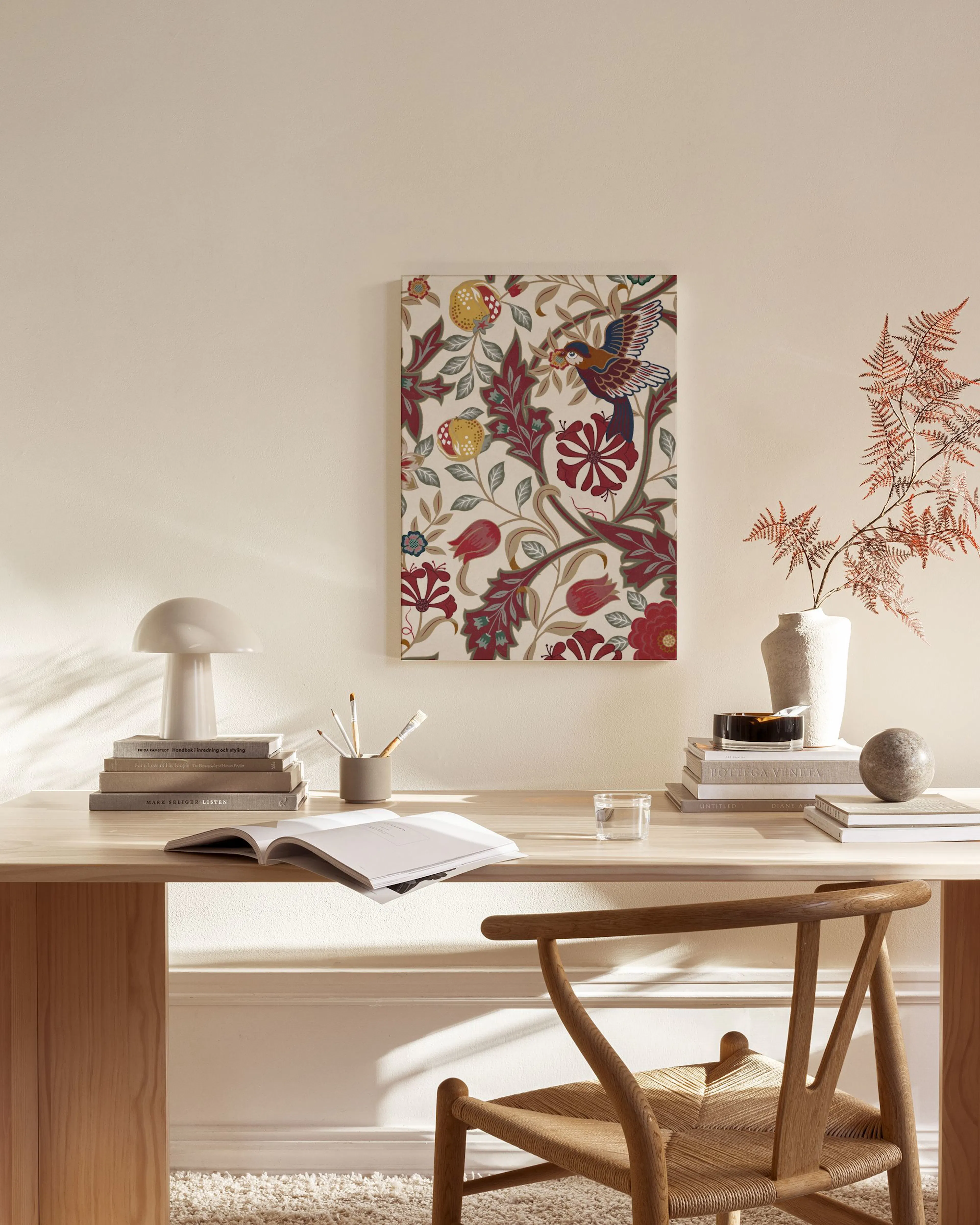 Leinwandbild mit floralem Muster und Vogel in Rot, Grün und Beige, über einem Sideboard im Wohnzimmer.
