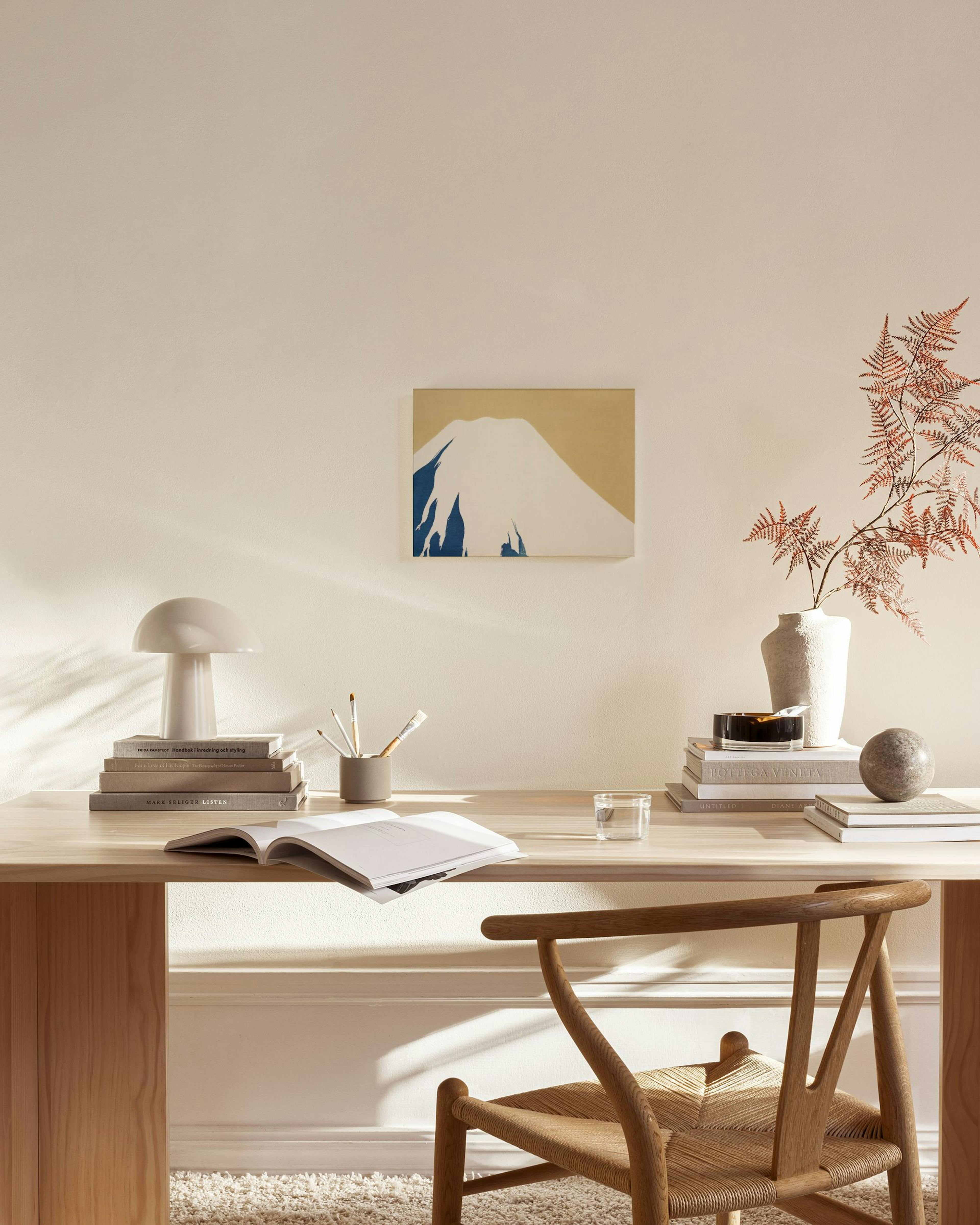 Obraz na plátne s abstraktným zobrazením hory Fudži v bielej a modrej farbe na béžovom pozadí, zavesený v obývačke.