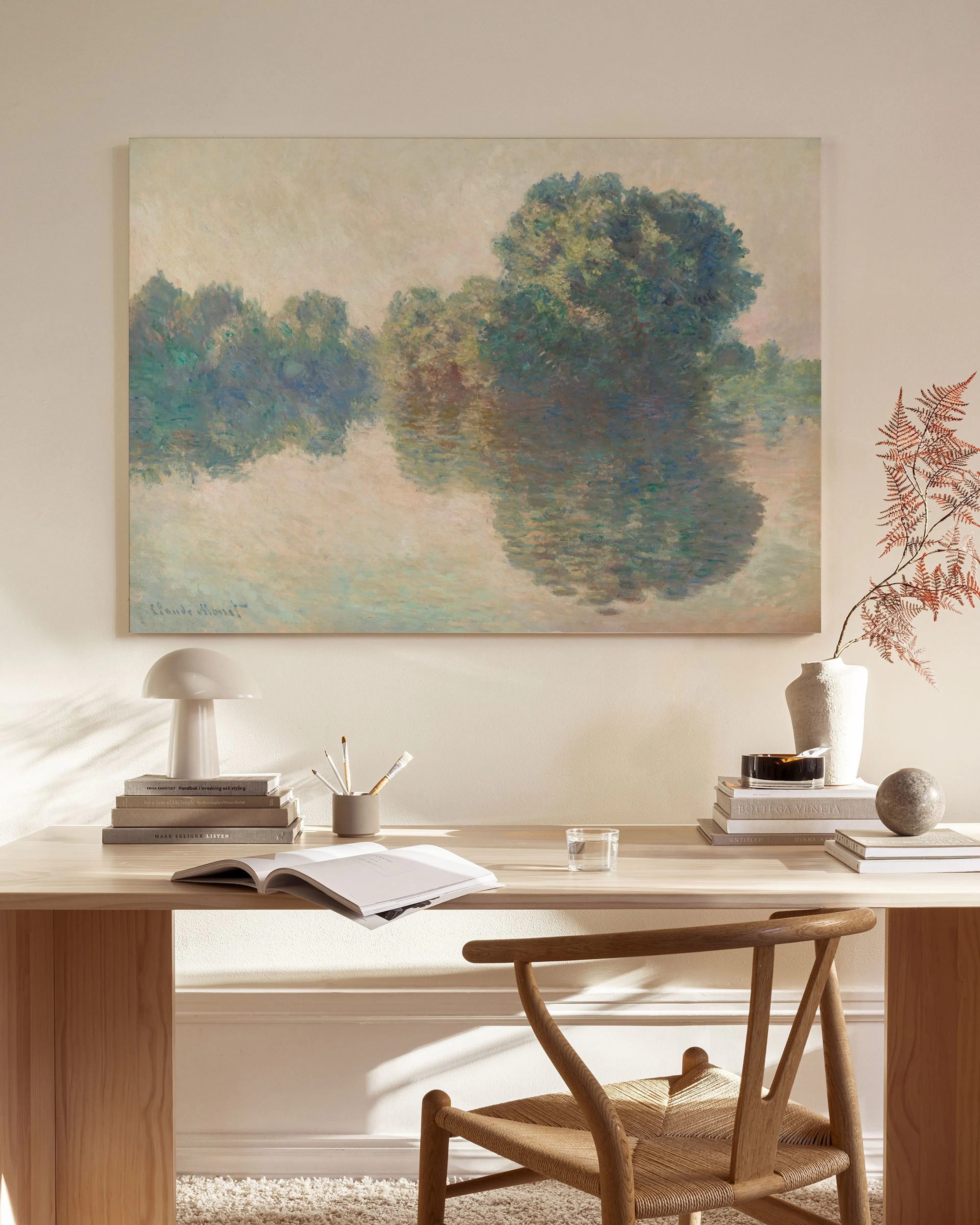 Impressionist river landscape canvas print with trees and reflections, hanging in a bright, minimalist living room.
