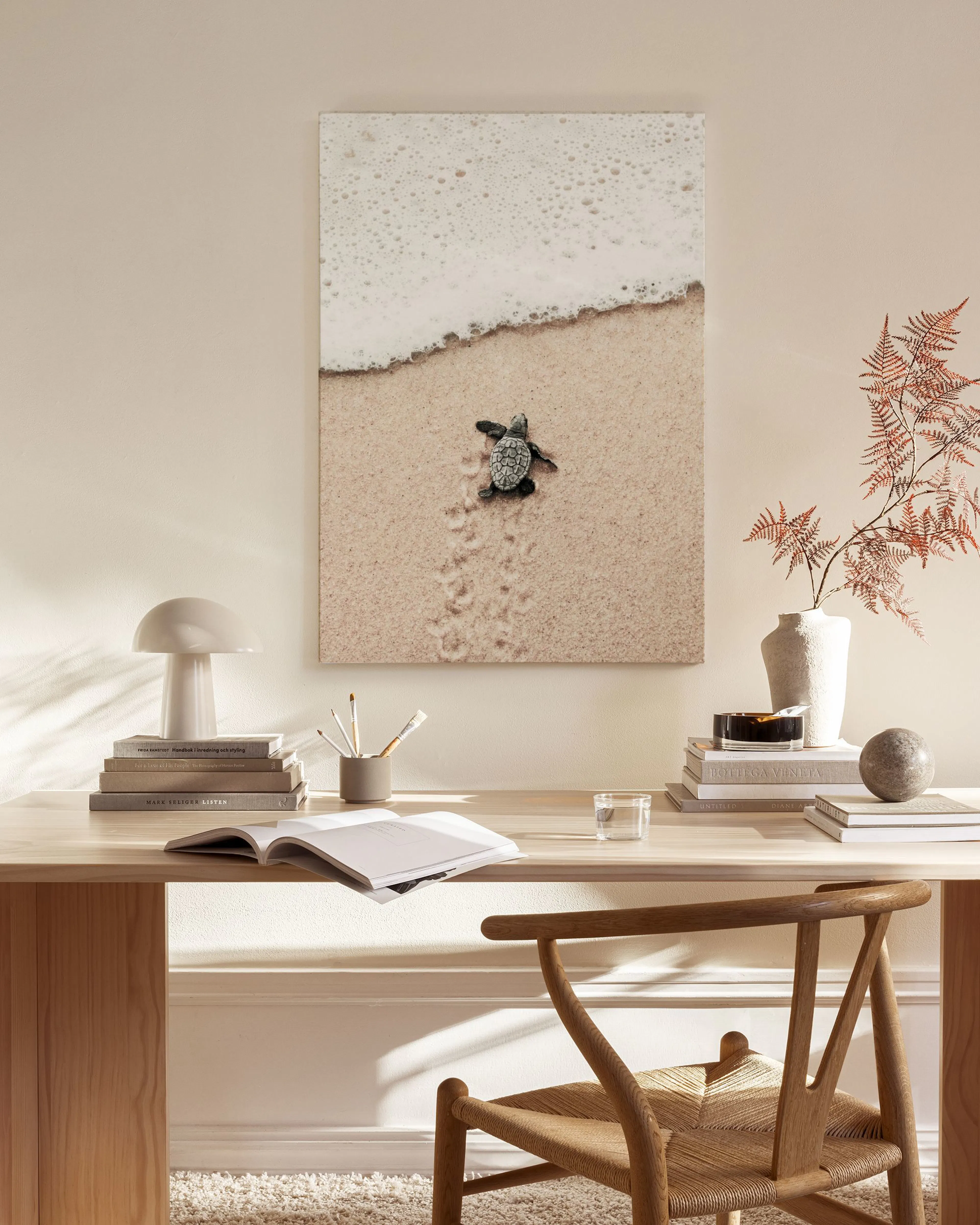 Leinwandbild einer Baby-Schildkröte auf dem Weg ins Meer, aufgehängt in einem hellen Wohnzimmer über einem Sideboard.