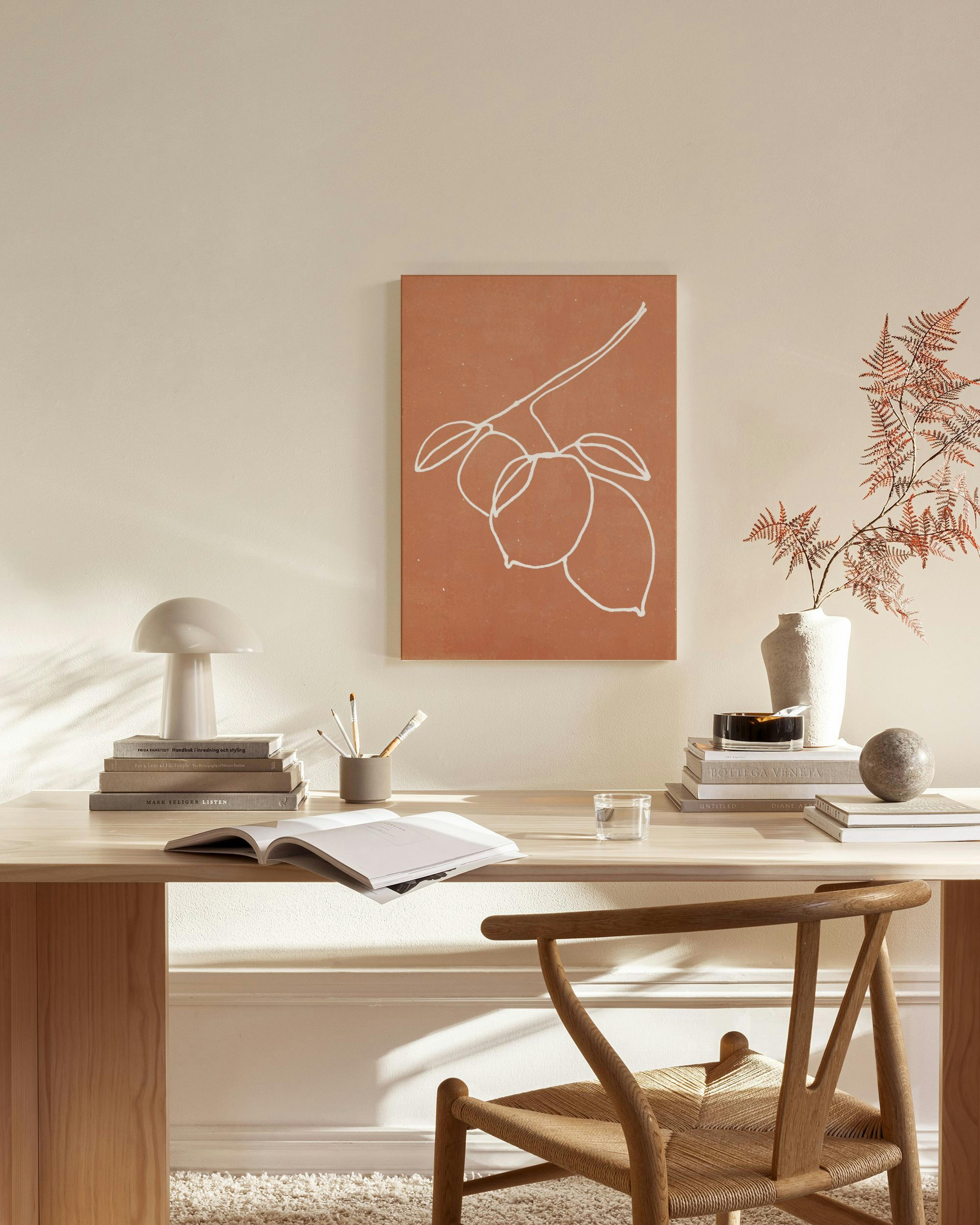 Linjapiirros sitruunoista oksalla, roikkuen modernissa olohuoneessa puisen penkin yllä.