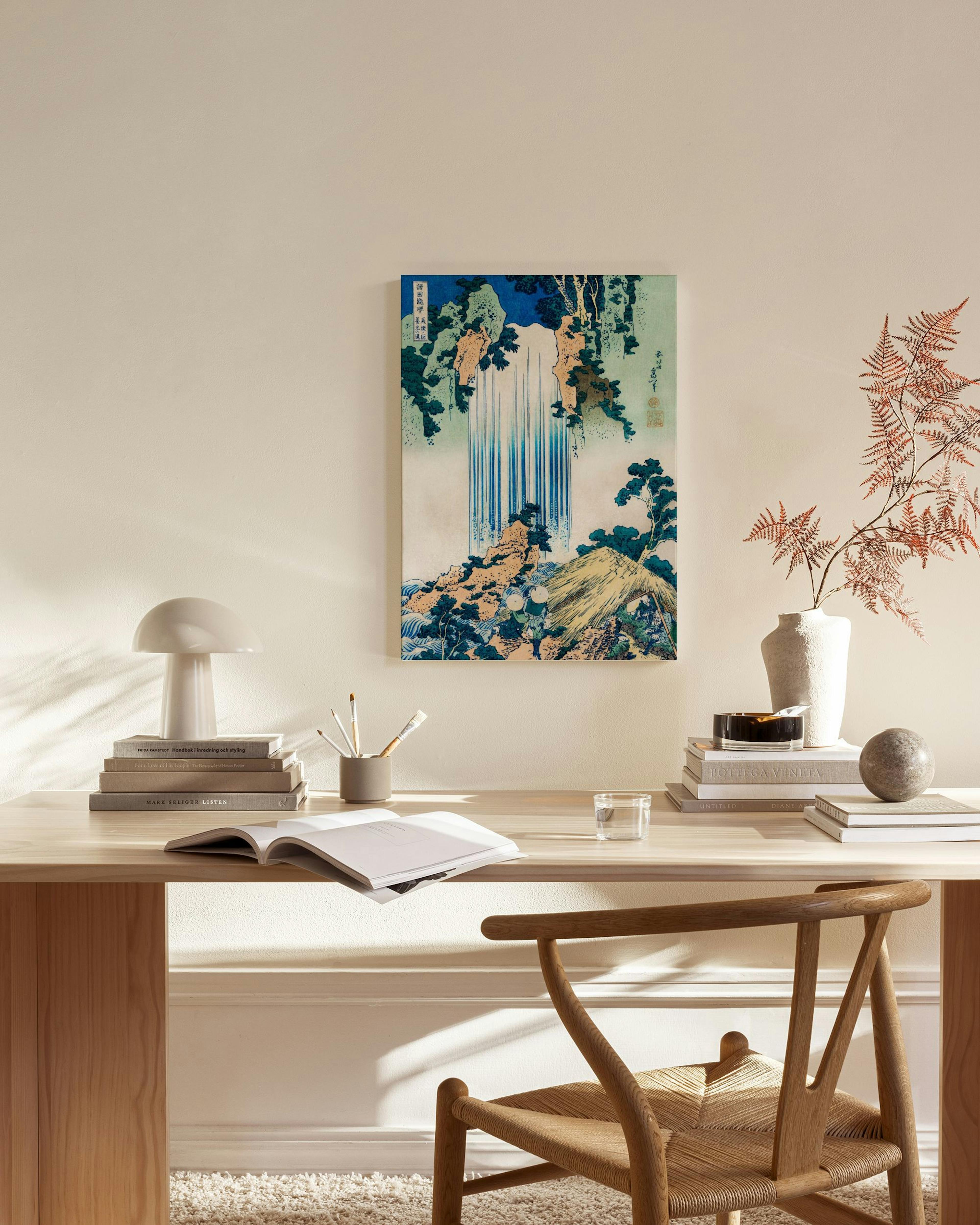 Lienzo japonés de cascada azul y verde en un diseño de ukiyo-e, colgado en una sala de estar moderna.