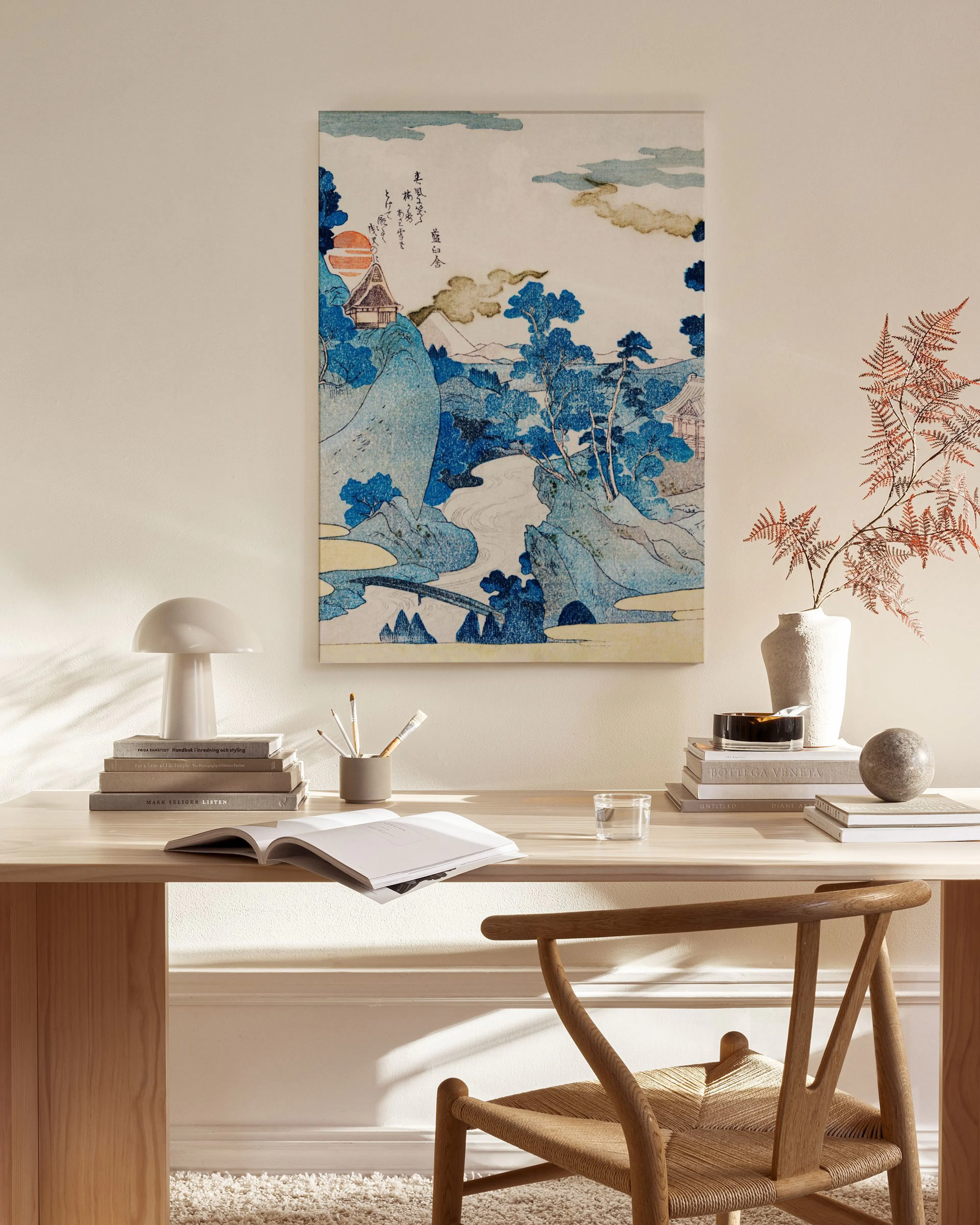 Toile japonaise traditionnelle aux tons bleus représentant un paysage de montagne avec un pont, accrochée dans un salon moderne.