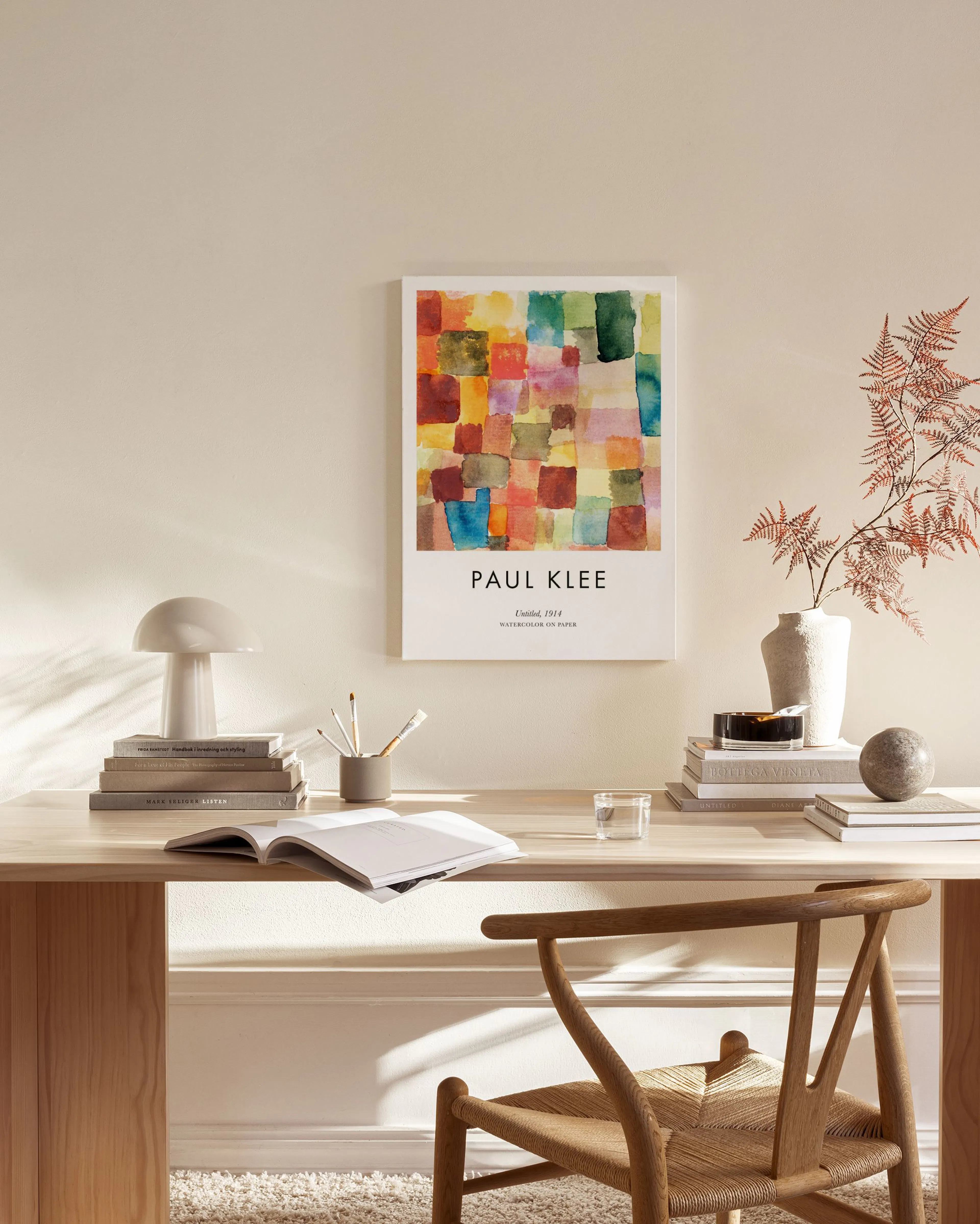 Lienzo de Paul Klee con bloques de color acuarela en tonos rojos, verdes y azules, colgado en una sala de estar minimalista.