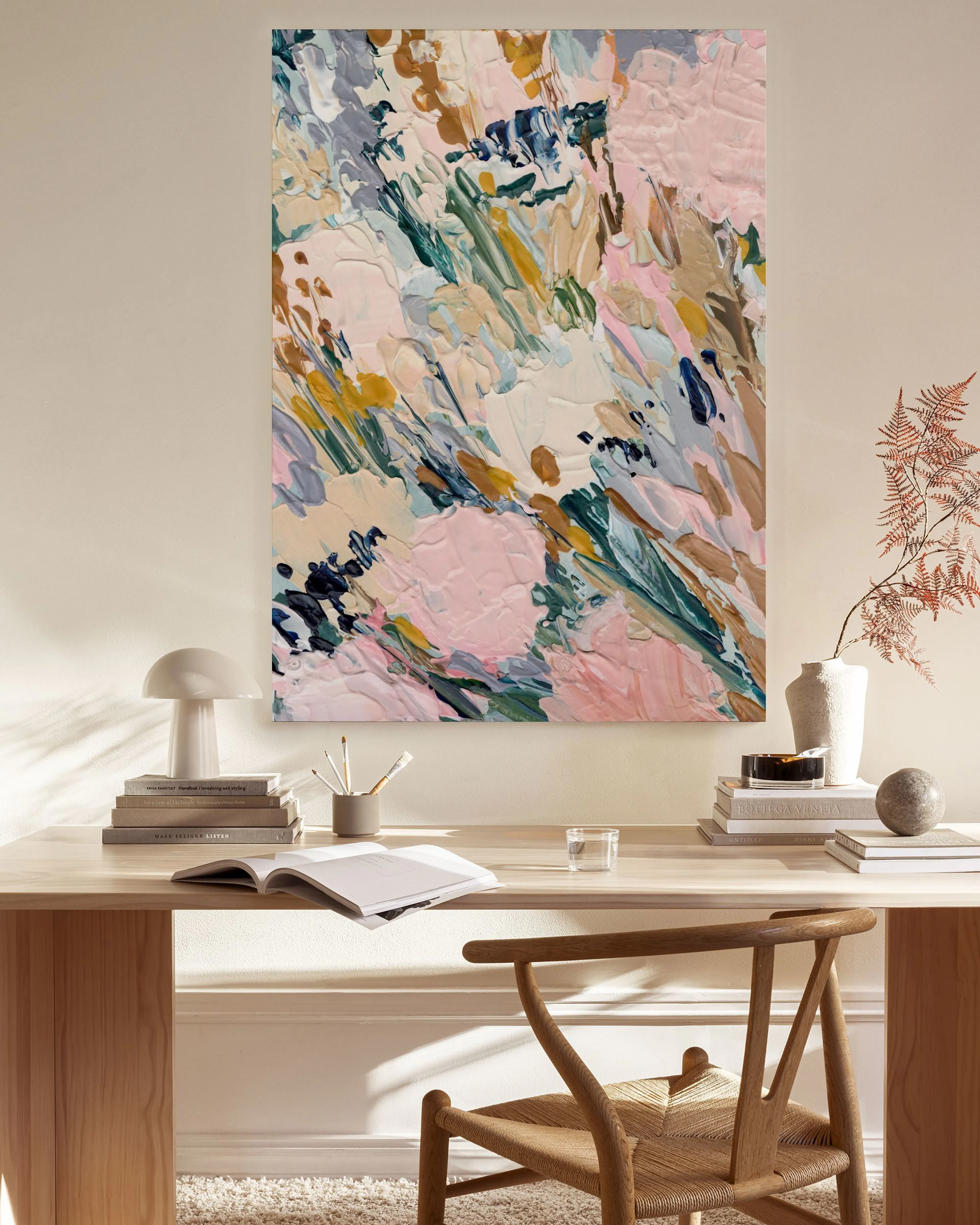 Leinwandbild mit abstrakten Pinselstrichen in Pastelltönen wie Rosa, Beige und Grün, hängend über einem Sideboard in einem moder
