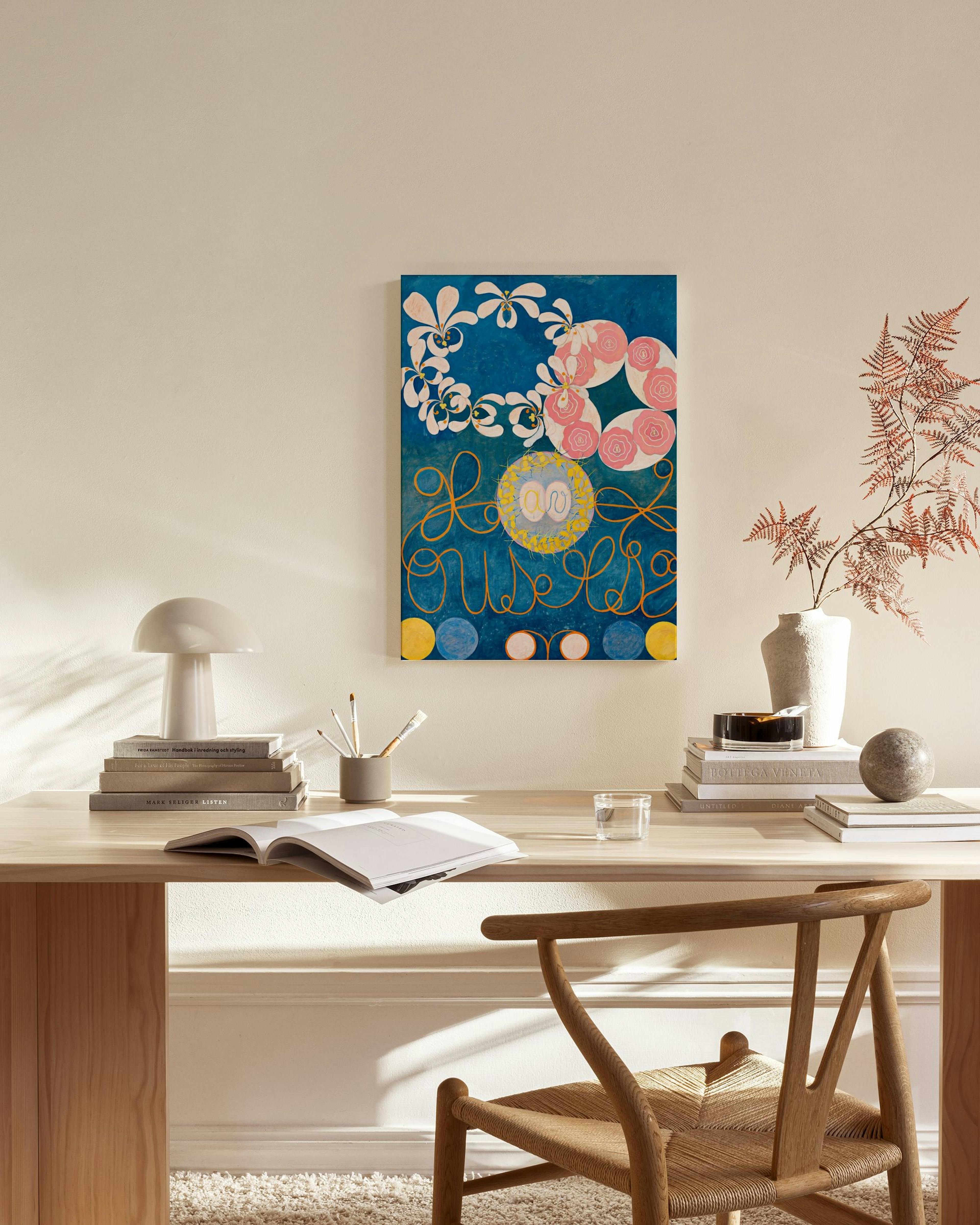 Leinwandbild mit floralen Elementen auf blauem Grund, gelben Schnörkeln und Kreisen, die an Buchstaben erinnern.