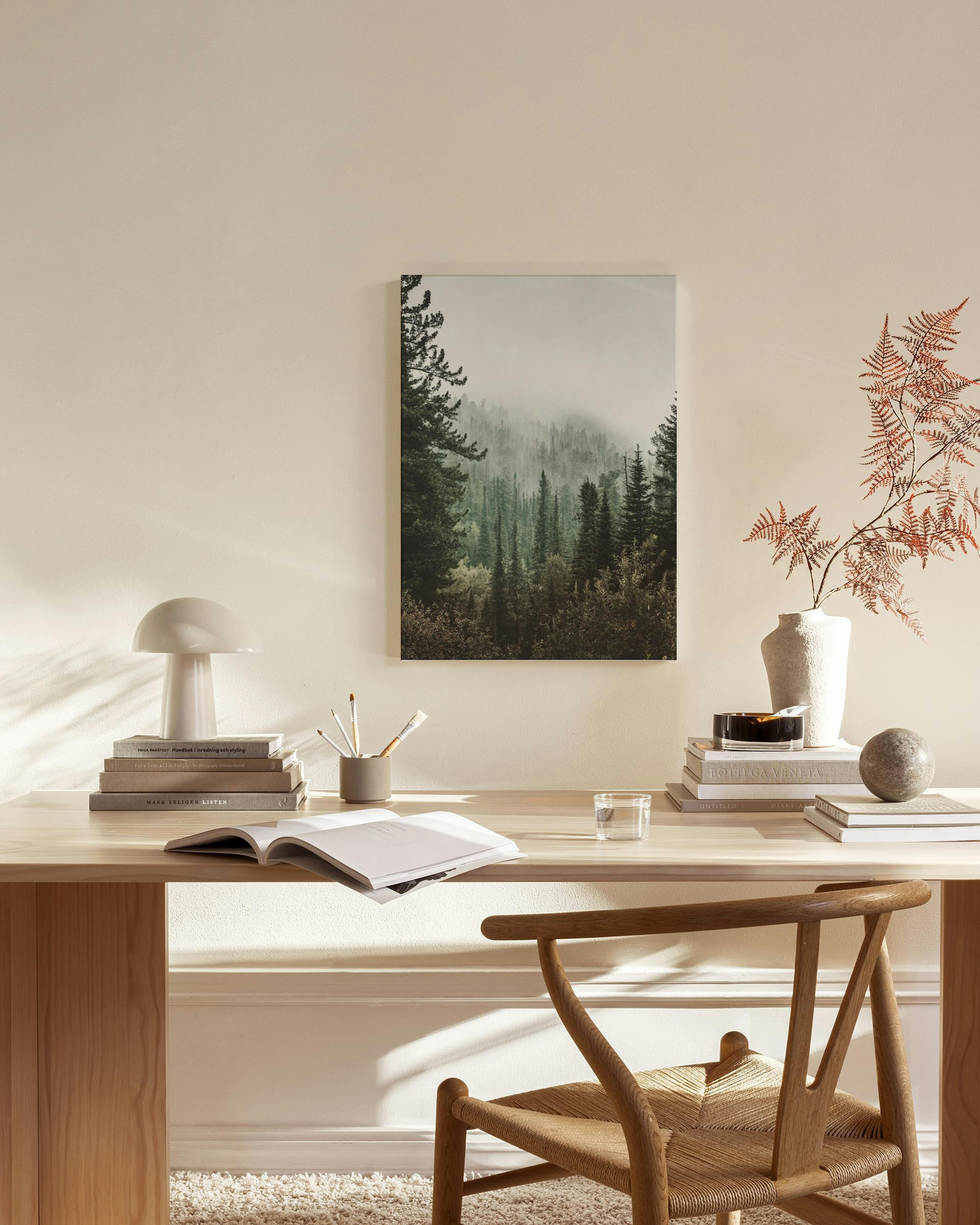 Leinwandbild mit nebelverhangenem Wald, aufgehängt in einem modernen Wohnzimmer über einem Sideboard.