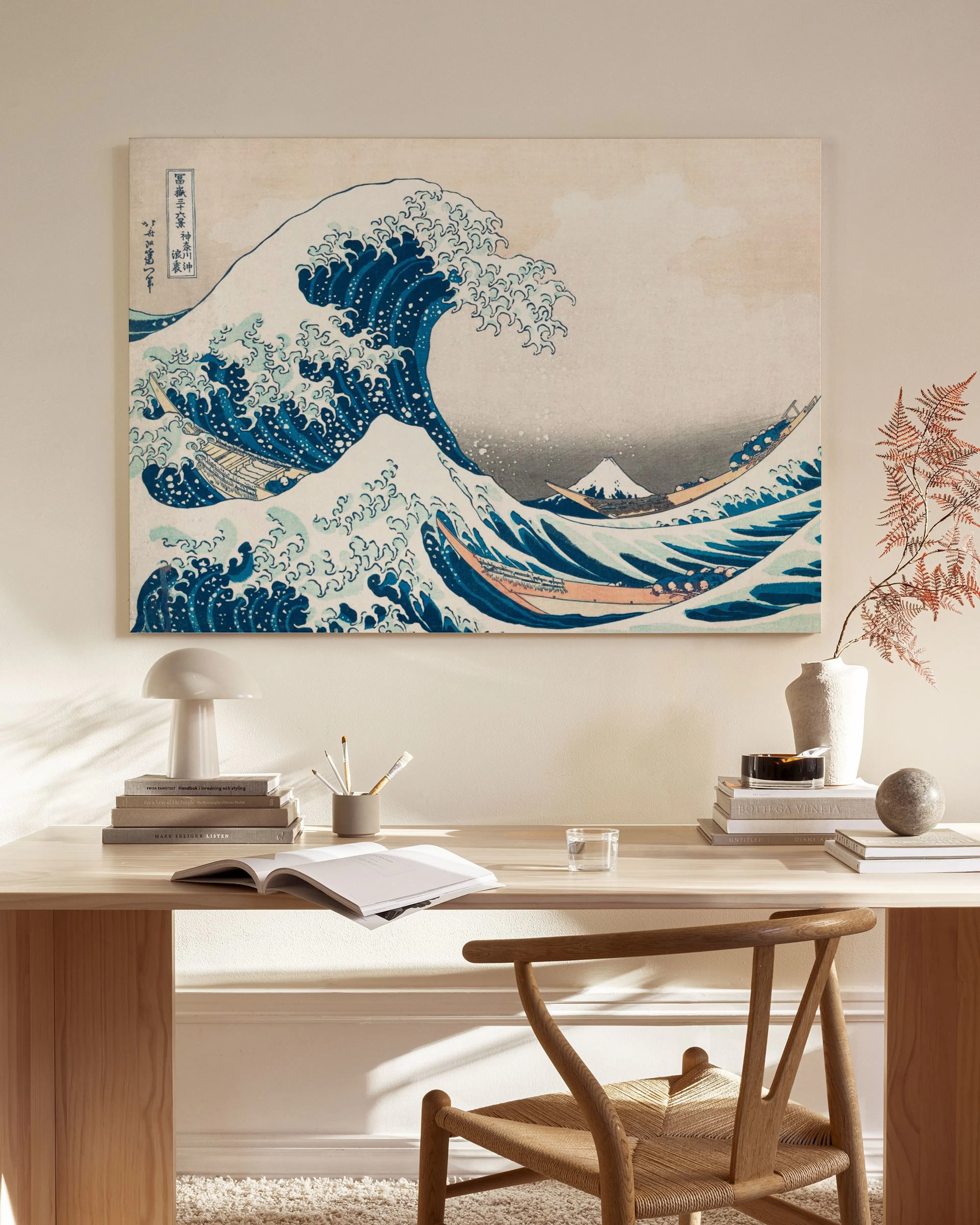 Lienzo de La Gran Ola de Kanagawa, con una enorme ola azul rompiendo y el monte Fuji al fondo, con reflejo.