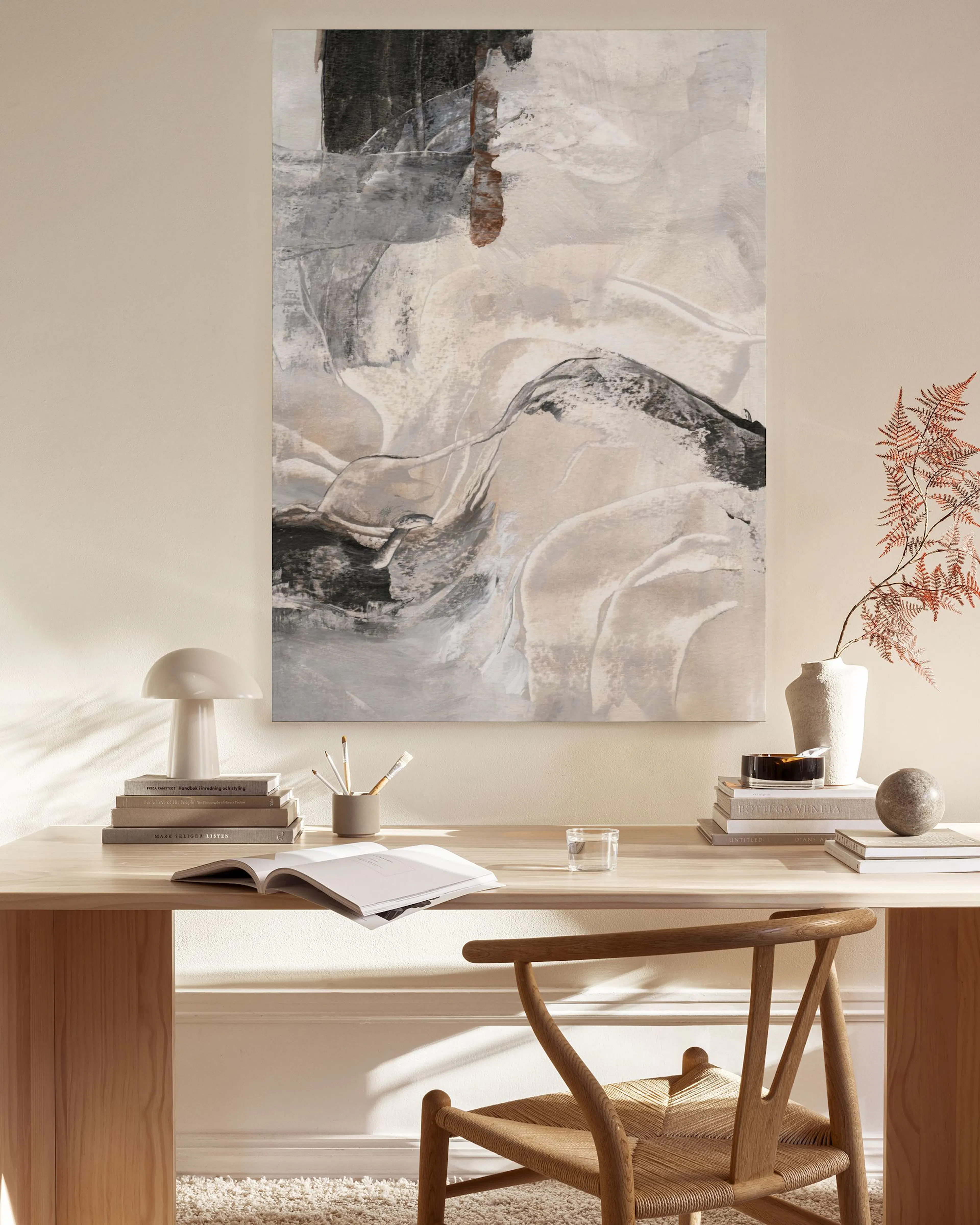 Toile abstraite aux formes organiques noir, blanc, beige, et gris, suspendue dans un salon moderne au-dessus dun banc.