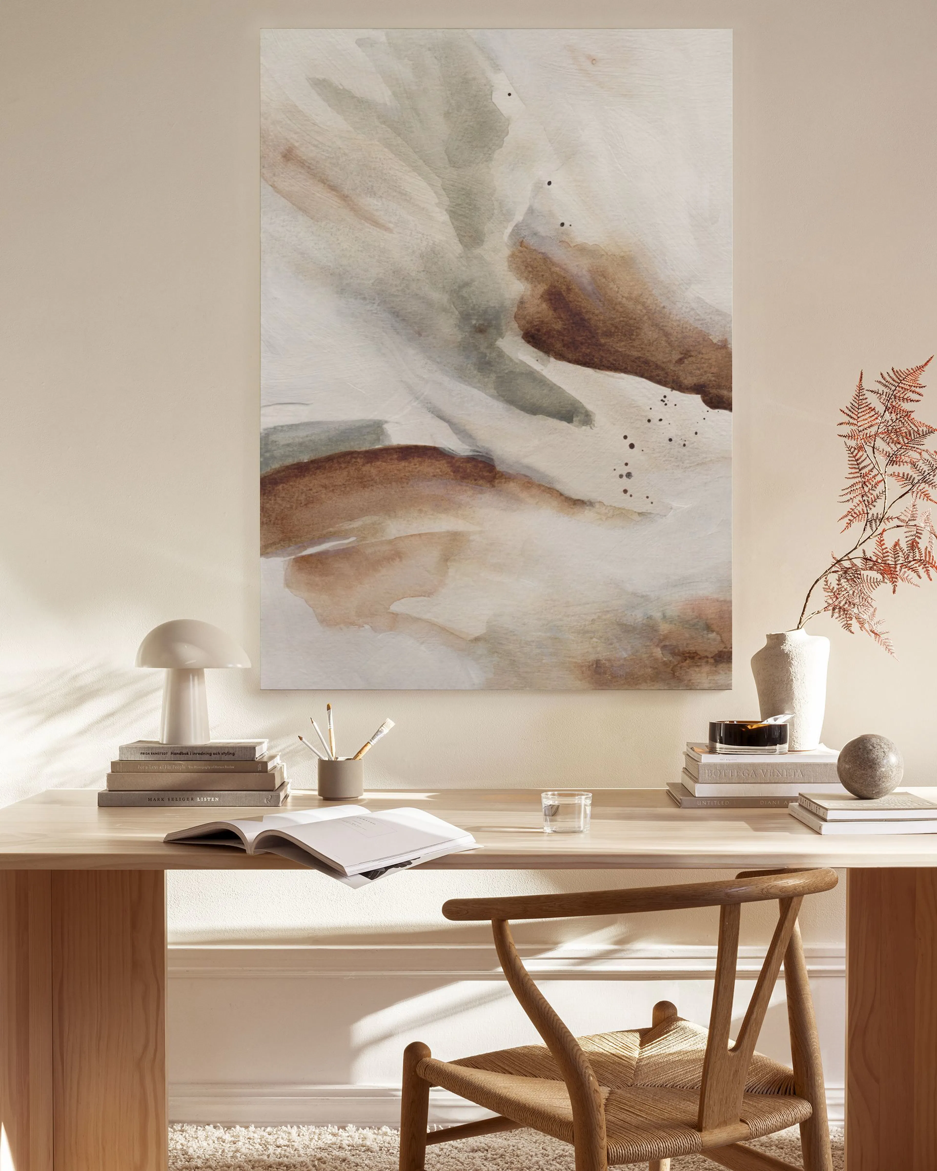 Abstraktes Leinwandbild mit erdigen Brauntönen und weiß-grauen Verläufen, hängend in einem hellen Wohnzimmer über einem Sideboar