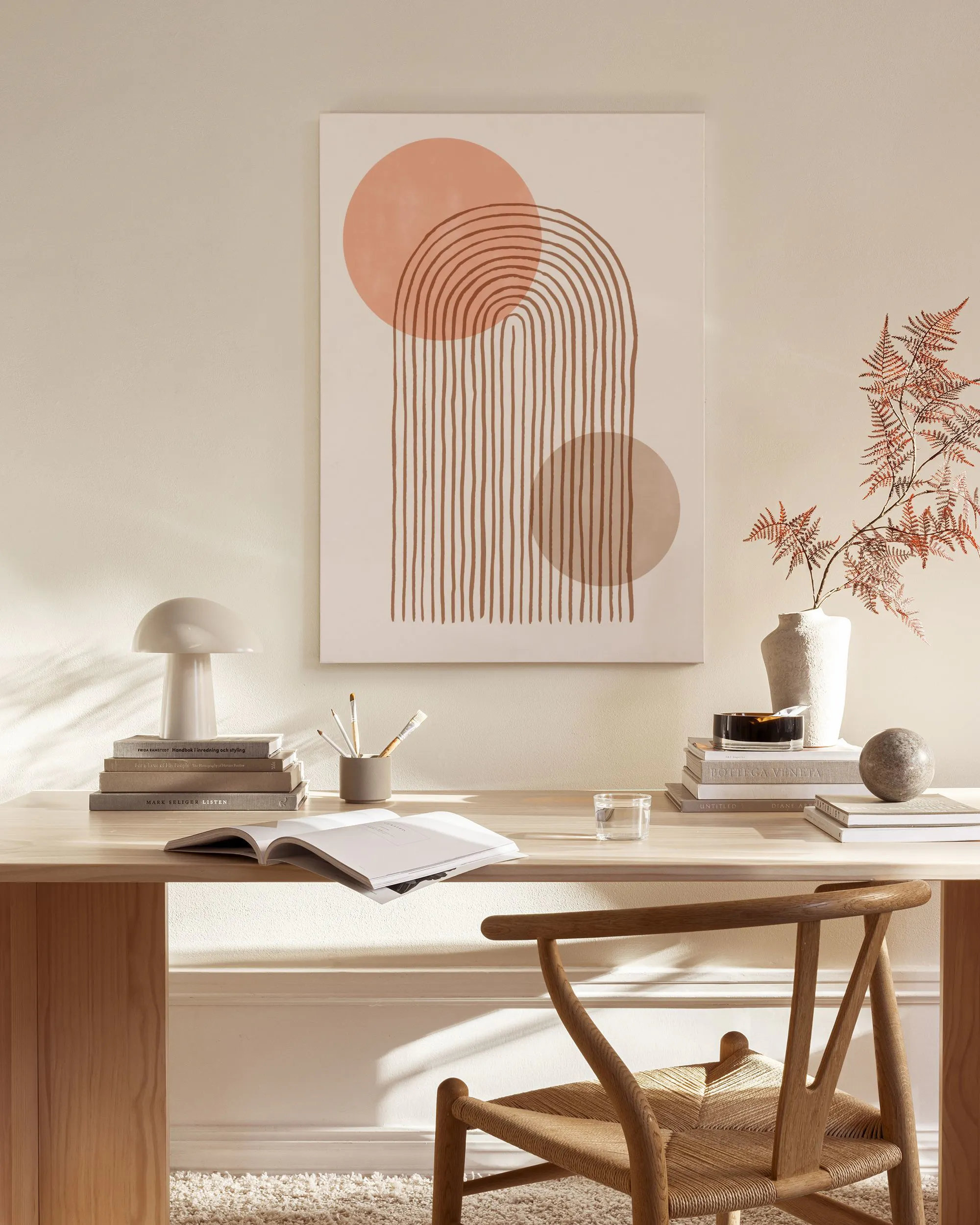 Canvas met roze en bruine ronde vormen en verticale lijnen, hangend in een lichte woonkamer.