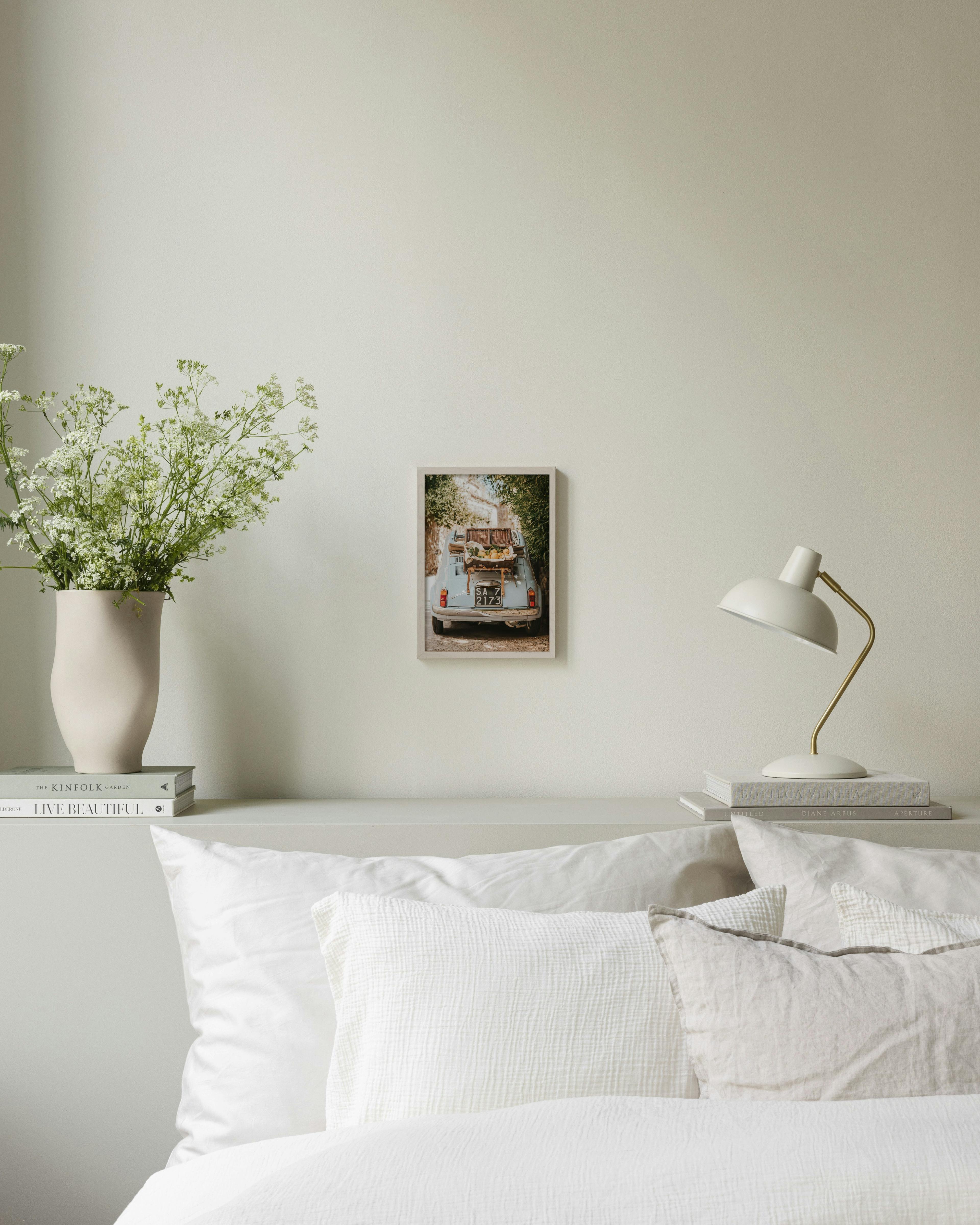 Πόστερ με μπλε ρετρό αυτοκίνητο Φίατ με καλάθι γεμάτο λεμόνια, κρεμασμένο πάνω από κρεβάτι σε υπνοδωμάτιο.