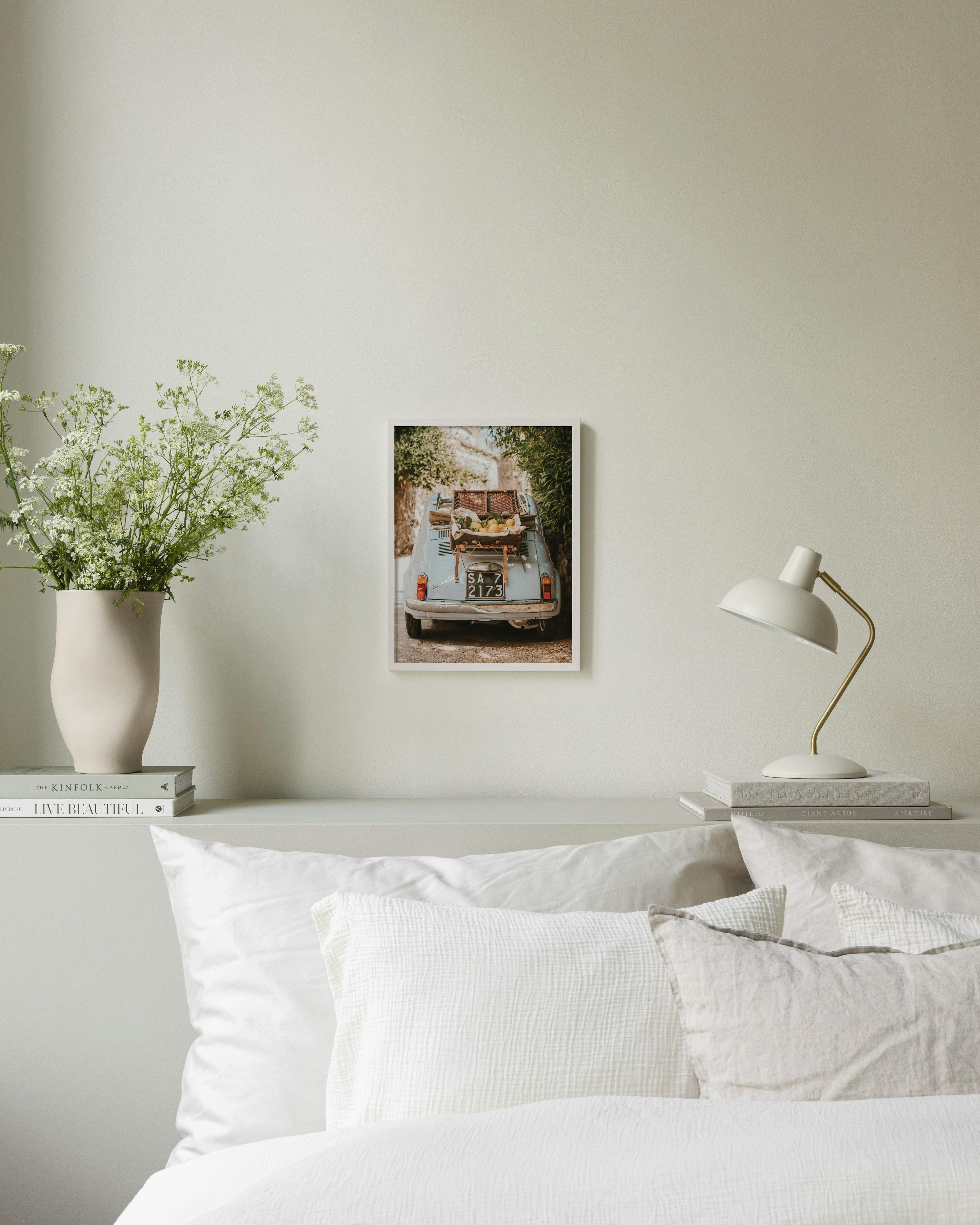 Plagát s modrým Fiatom 500 naloženým citrónmi, visí nad posteľou v spálni.