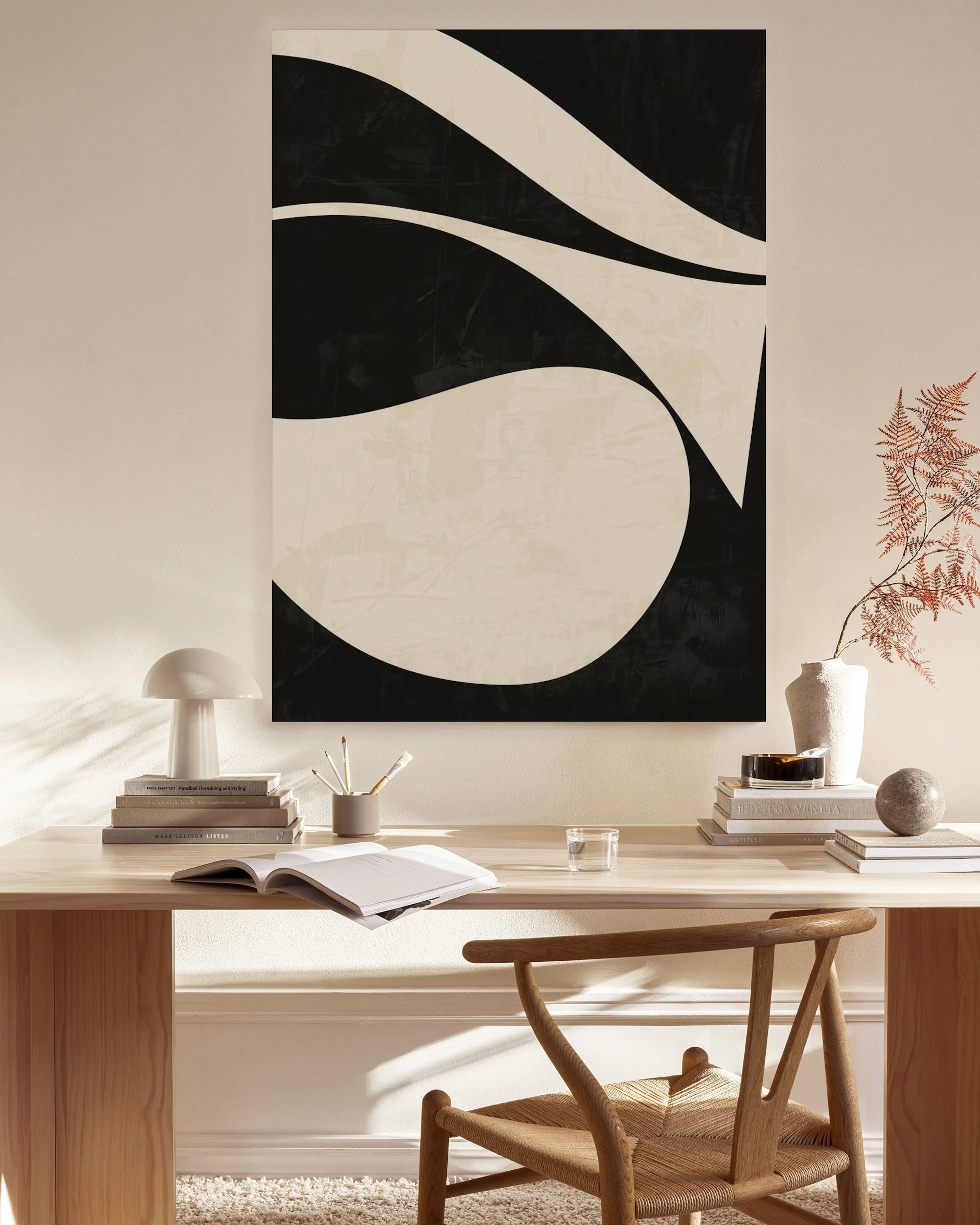 Monochromatic canvas print with flowing black and beige abstract shapes, and subtle texture.