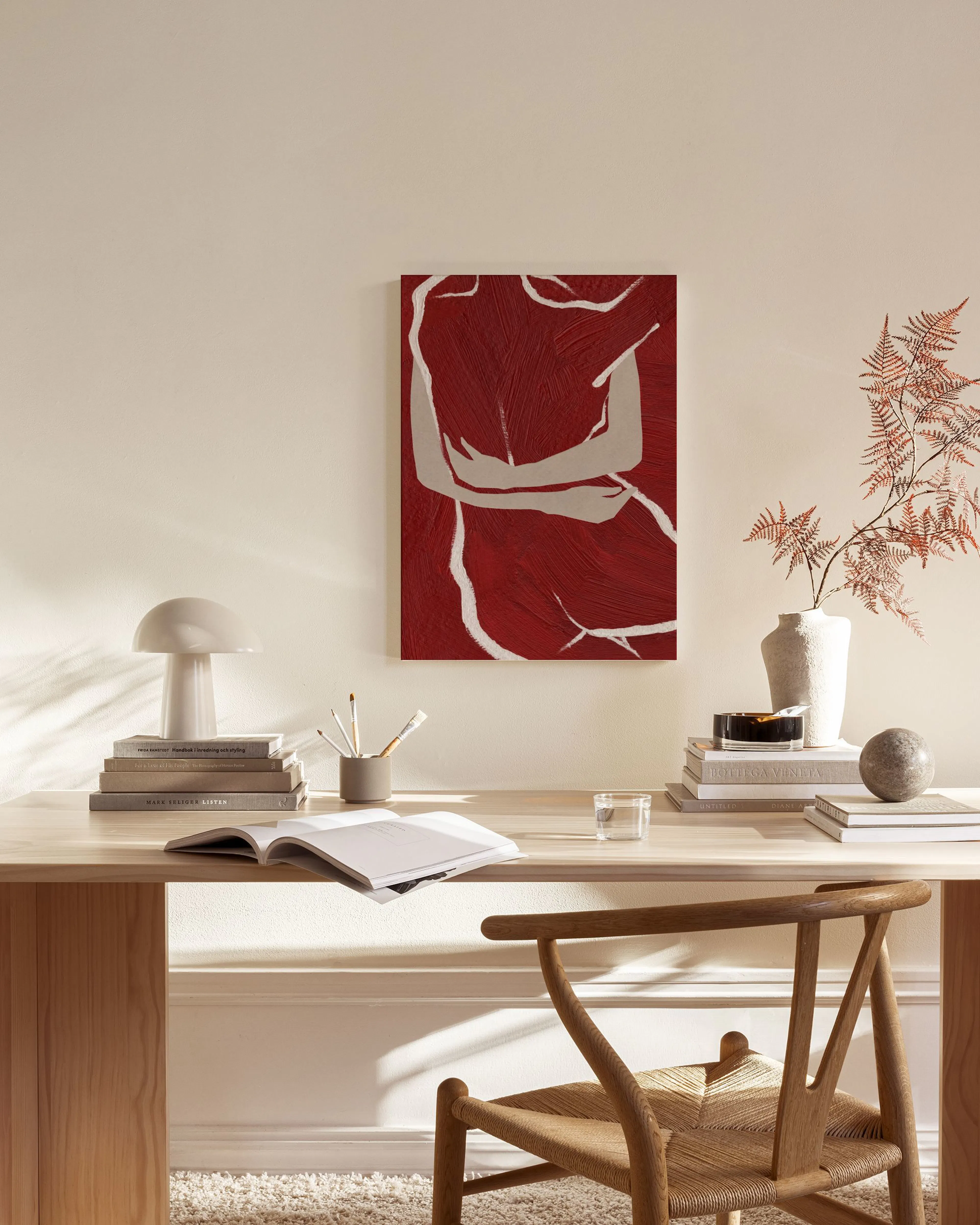 Toile murale abstraite rouge et beige avec des formes corporelles, suspendue dans un salon moderne aux tons neutres.