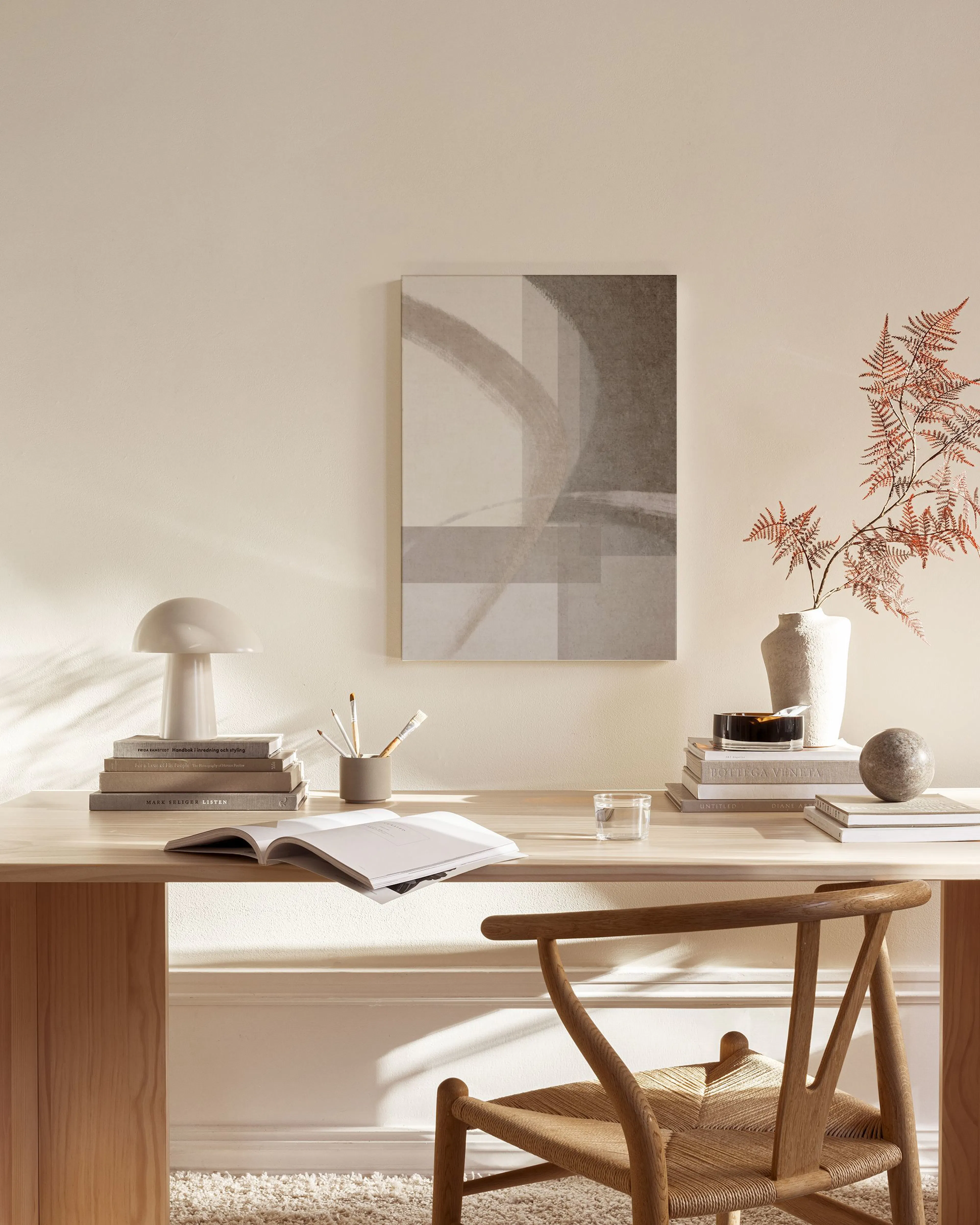 Abstrakte Leinwandbild mit grauen und beigen geometrischen Formen, hängend über einem Sideboard im Wohnzimmer.