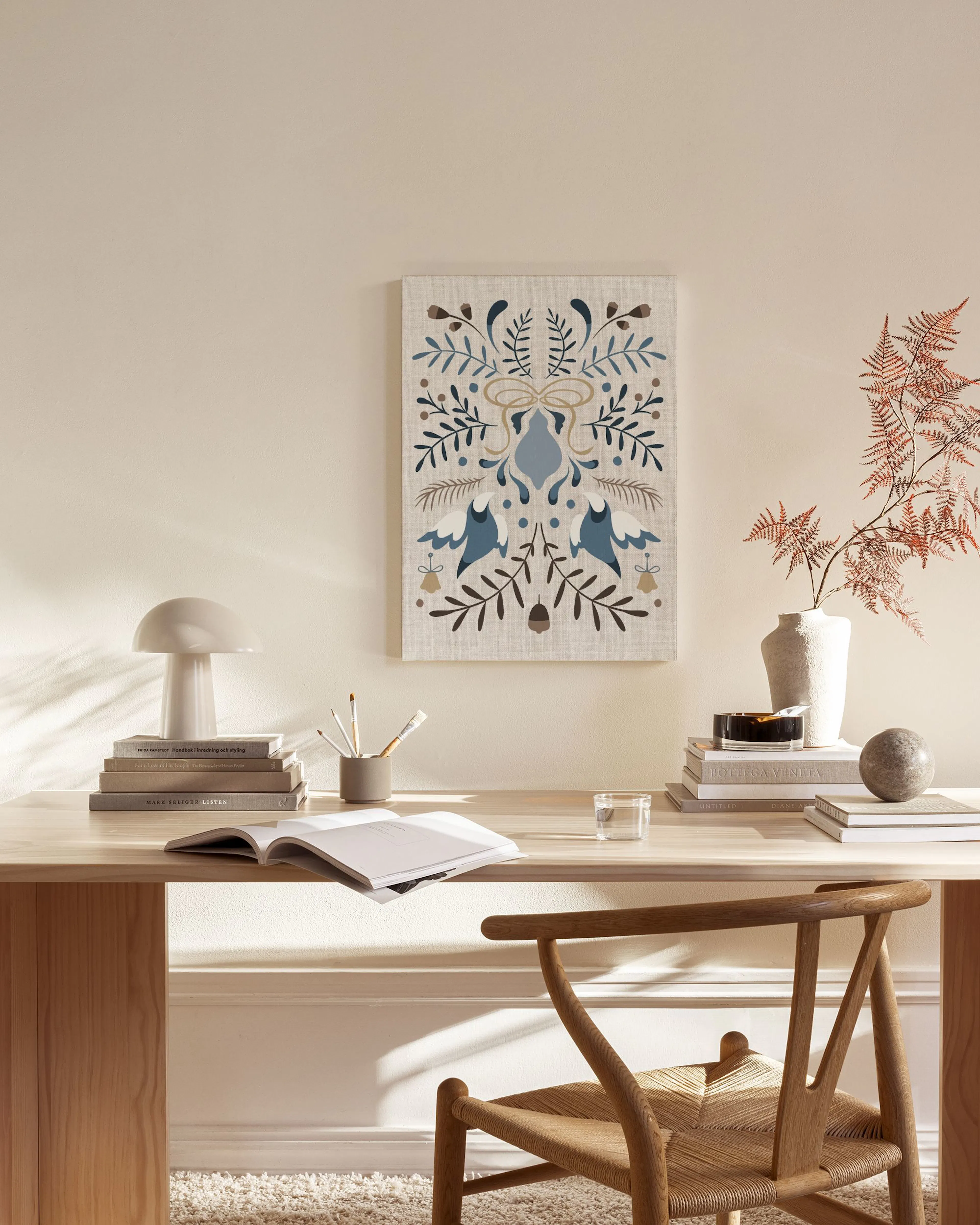 Canvas met blauw en bruin folkloristisch patroon van bloemen en vogels, hangend boven een houten dressoir in een lichte woonkame