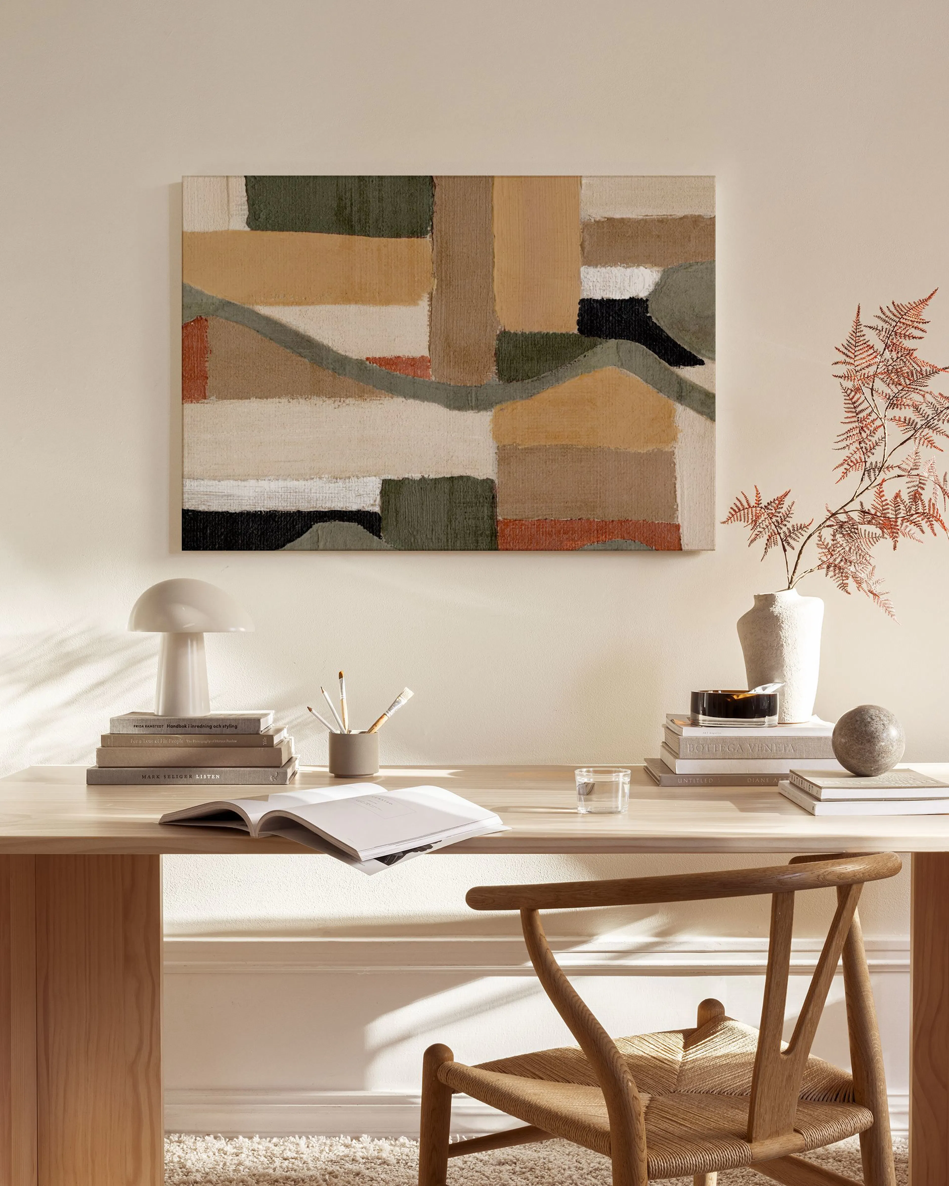 Leinwandbild mit abstrakten Formen in Naturtönen, Beige, Grün und Rostrot, über einem Sideboard im Wohnzimmer.