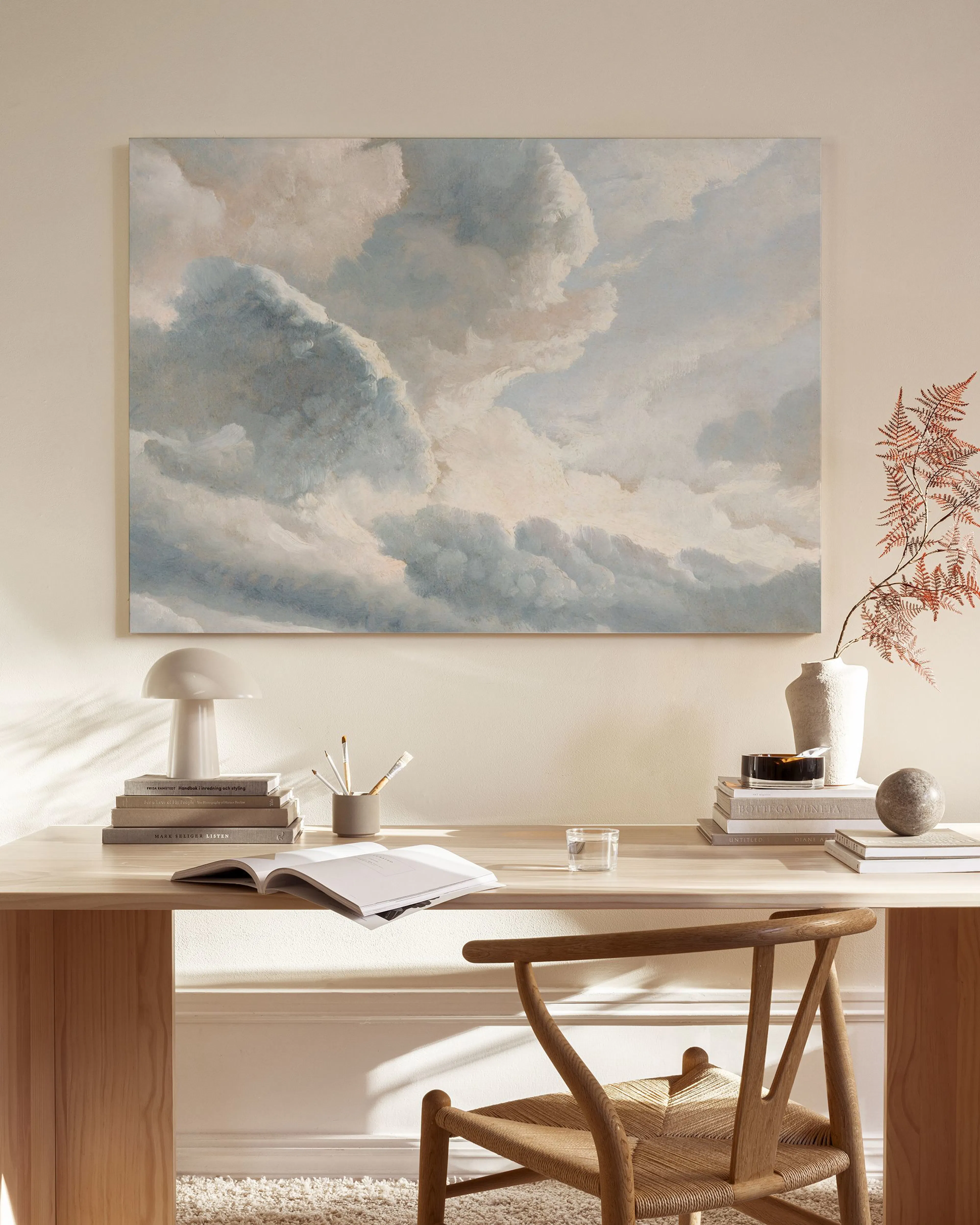 Toile murale représentant des nuages blancs et gris détaillés, éclairés par le soleil, dans un ciel bleu pâle.