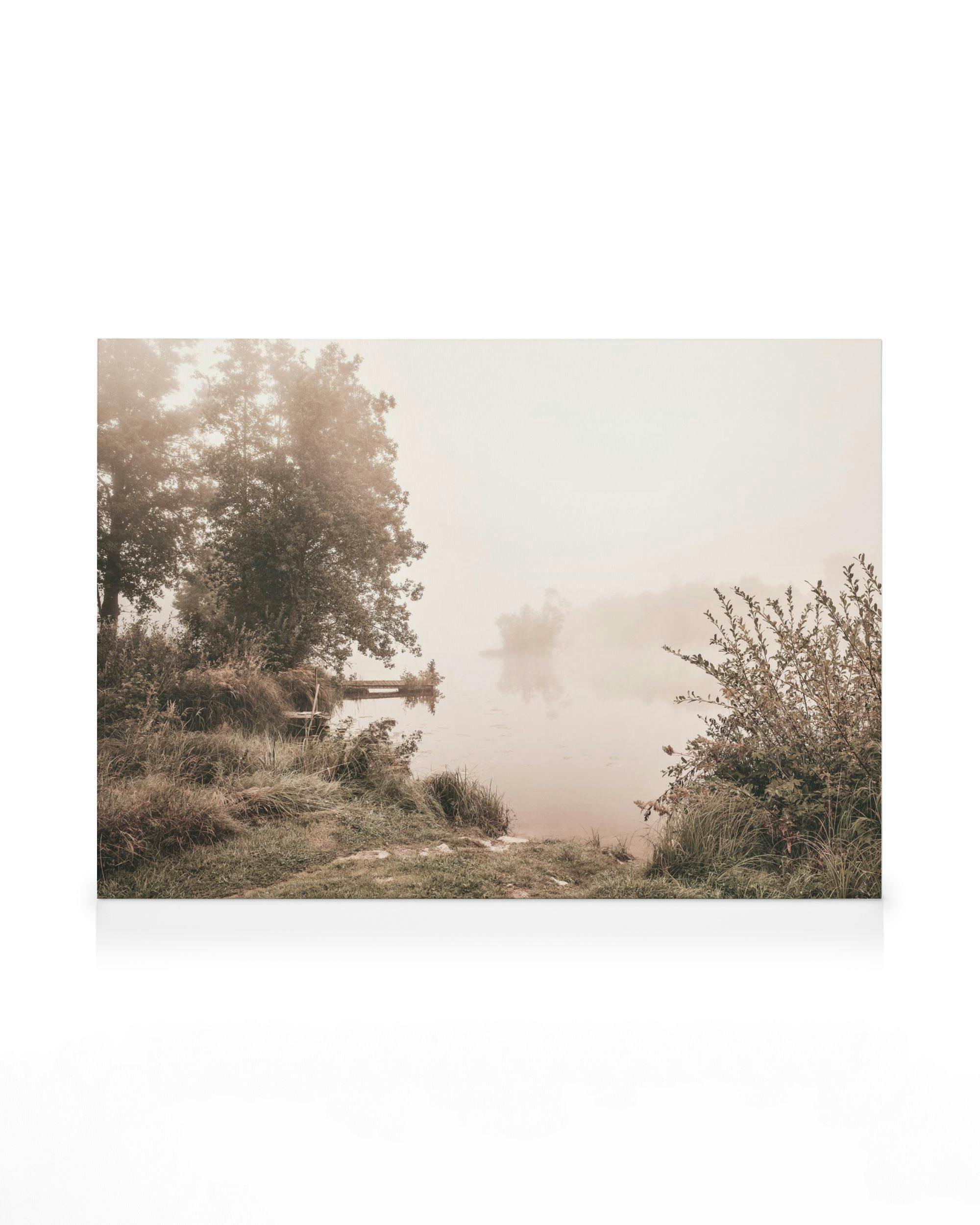 Misty Morning Lake canvas print, serene foggy lake with trees reflected on calm water, muted greens and whites.