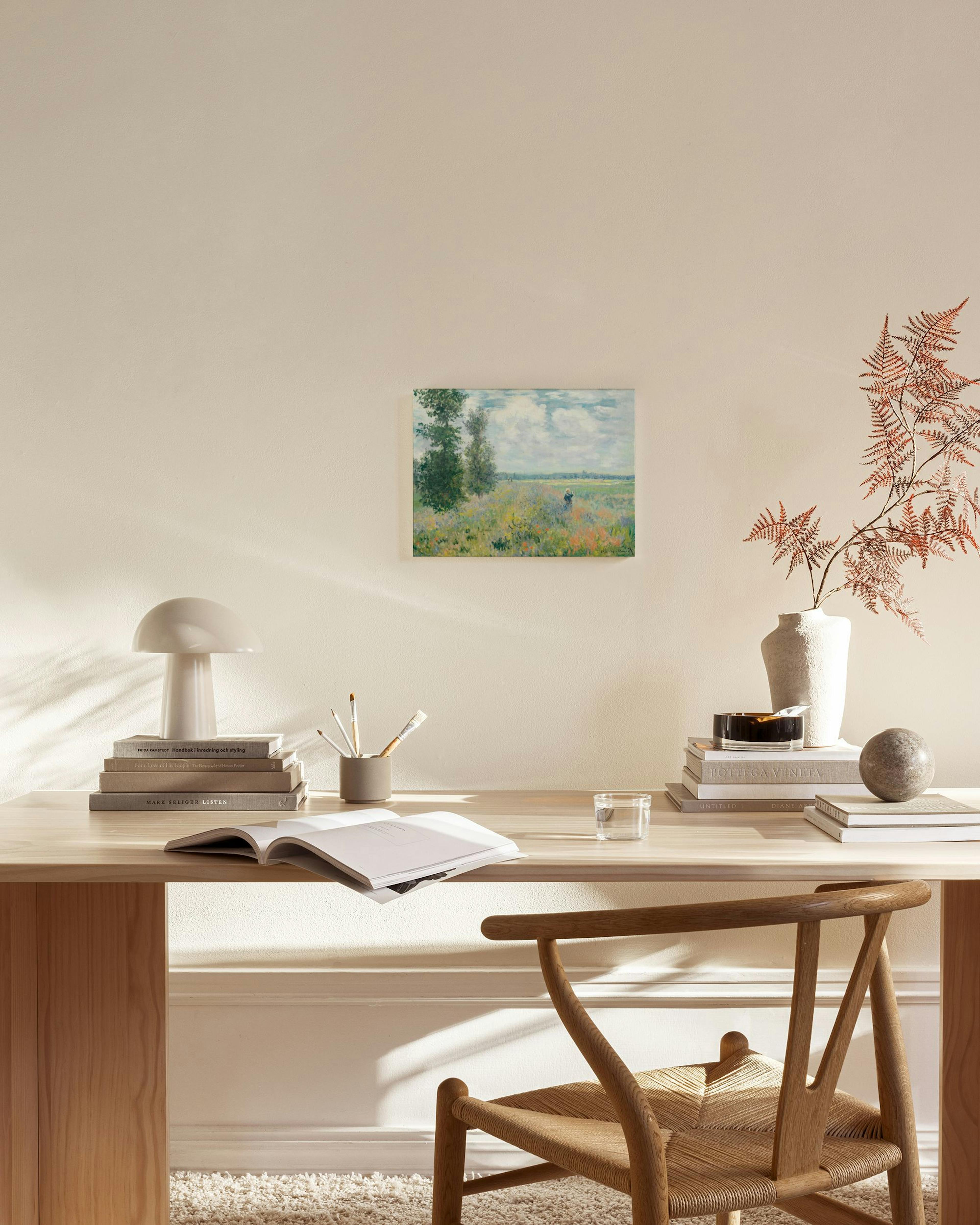 Stampa su tela di un paesaggio impressionista con campo fiorito e alberi, appesa in un salotto moderno.