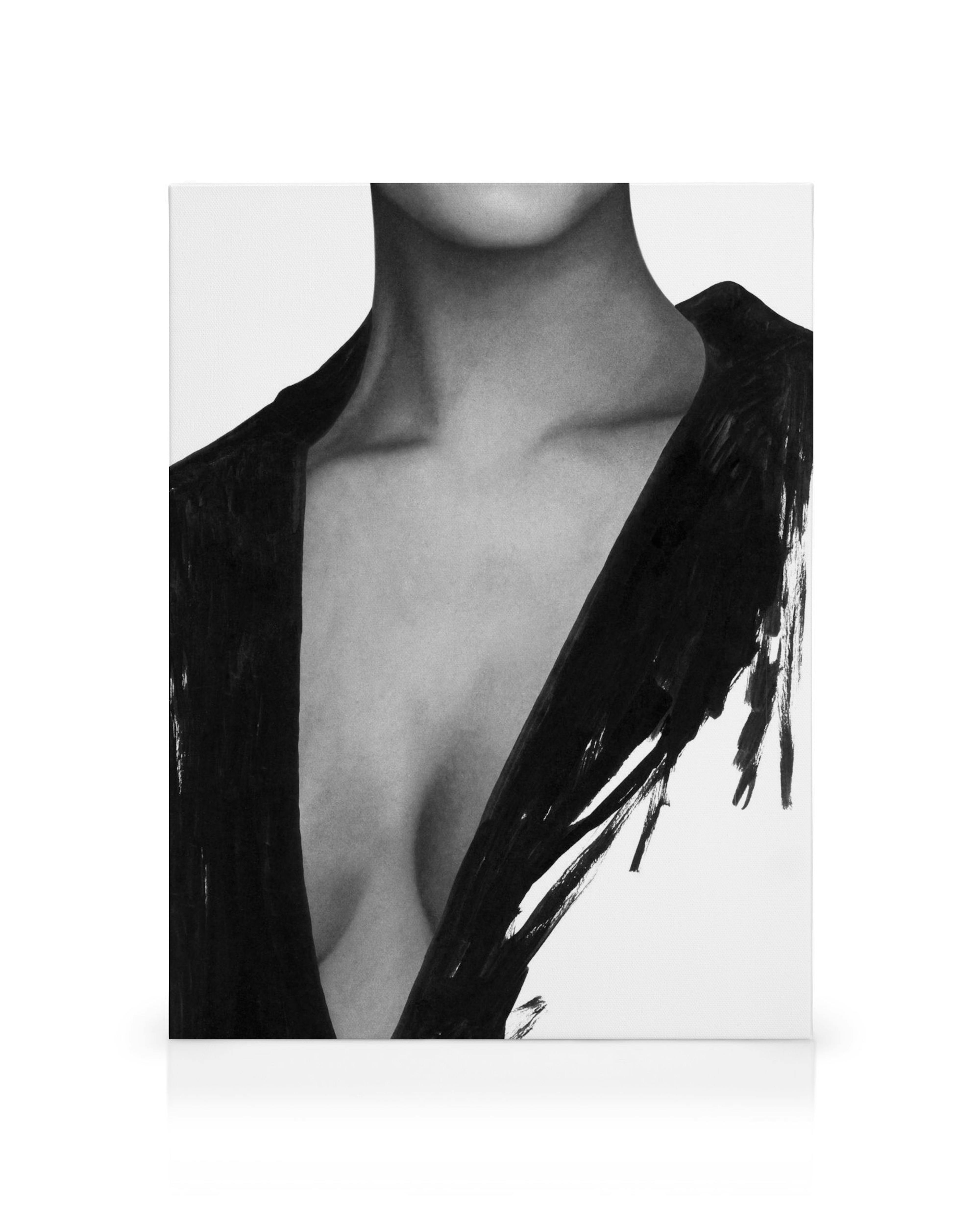 Černobílý ženský náčrt s hrudí a částí obličeje, s výraznými tahy štětce, v popředí umělecký obraz na plátně.