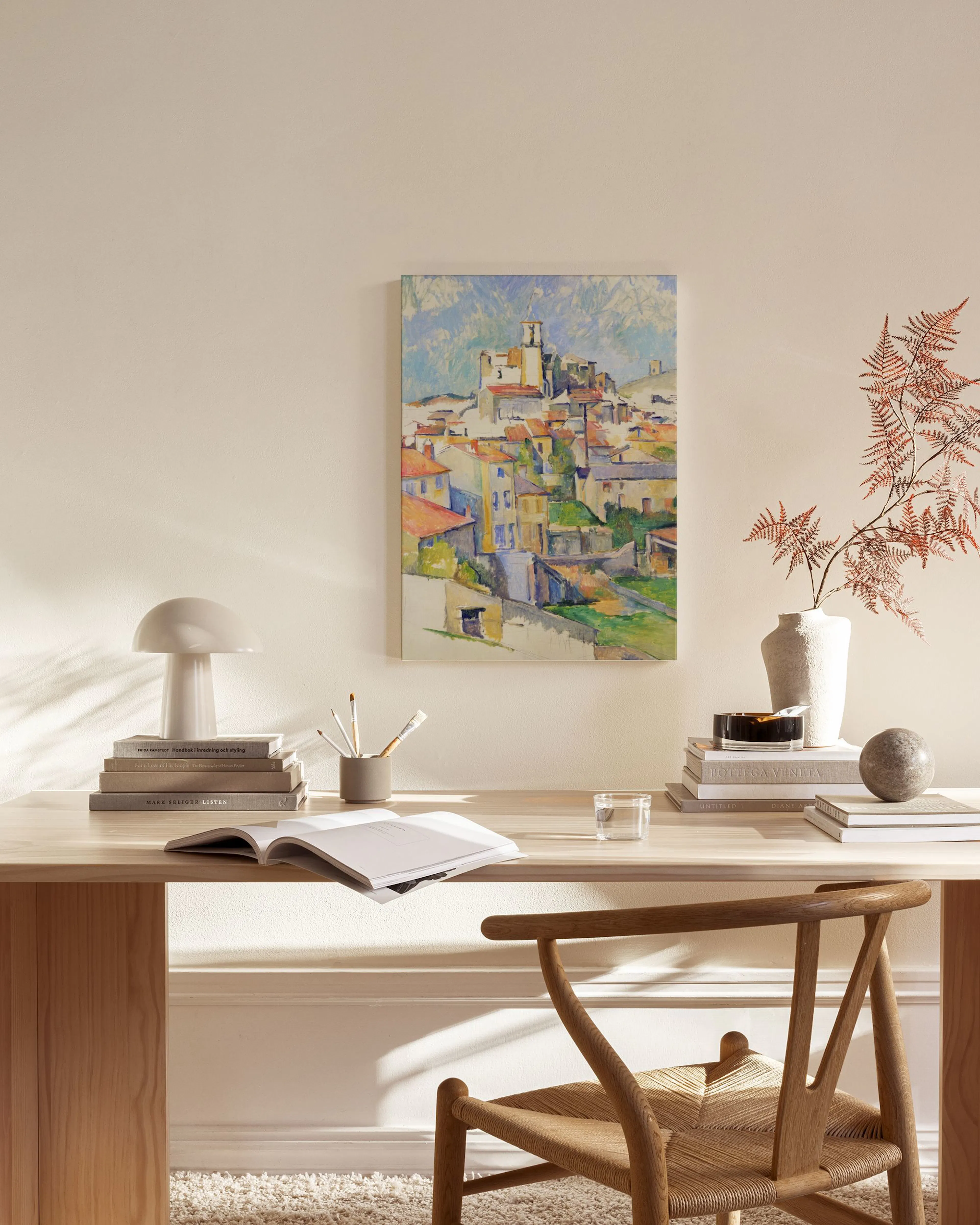 Toile dun village méditerranéen avec des maisons colorées et un château en hauteur, accrochée dans un salon moderne.