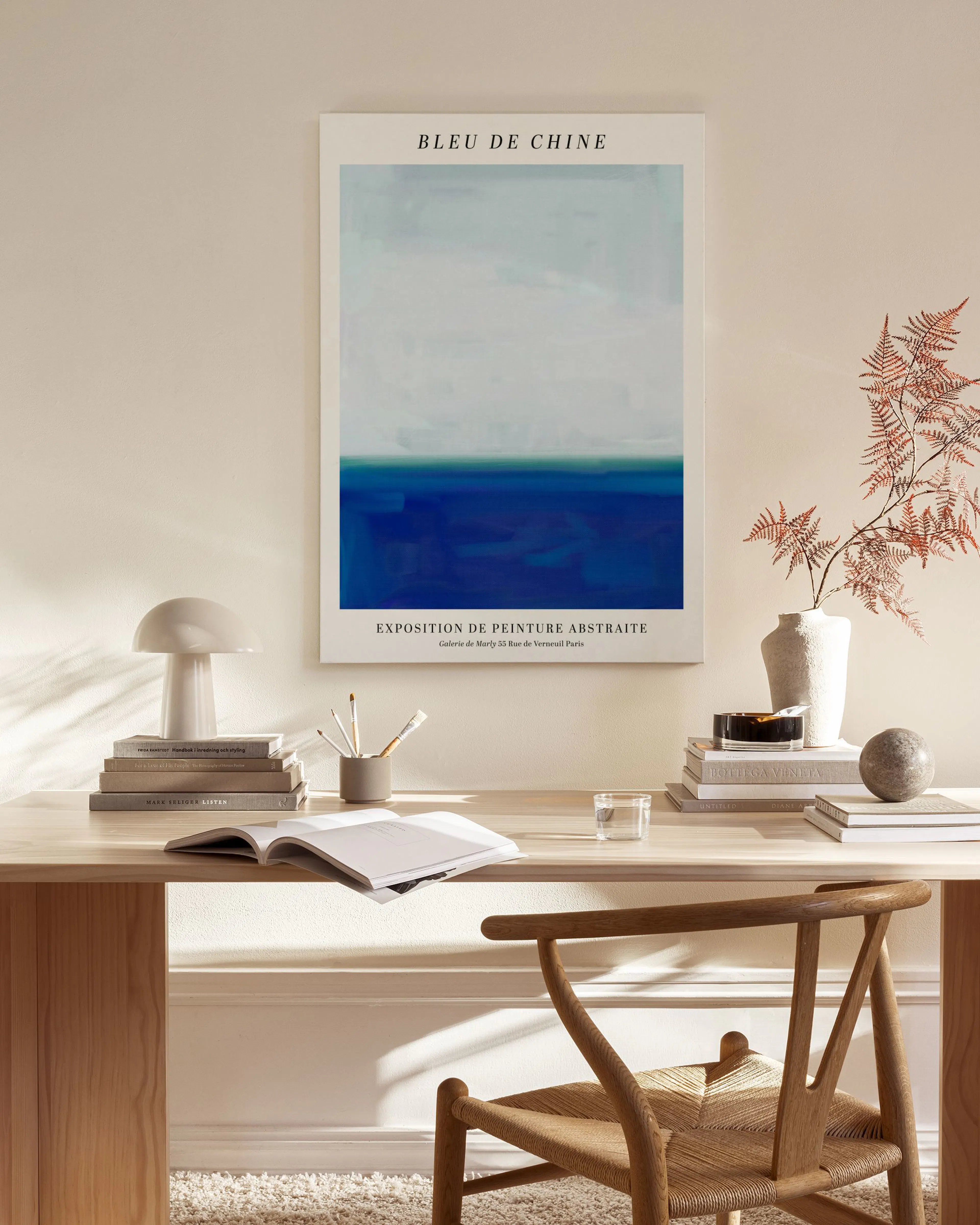 Leinwandbild mit abstraktem, blauem Horizont, der an ein Meer erinnert, hängt über einem Sideboard in einem Wohnzimmer.