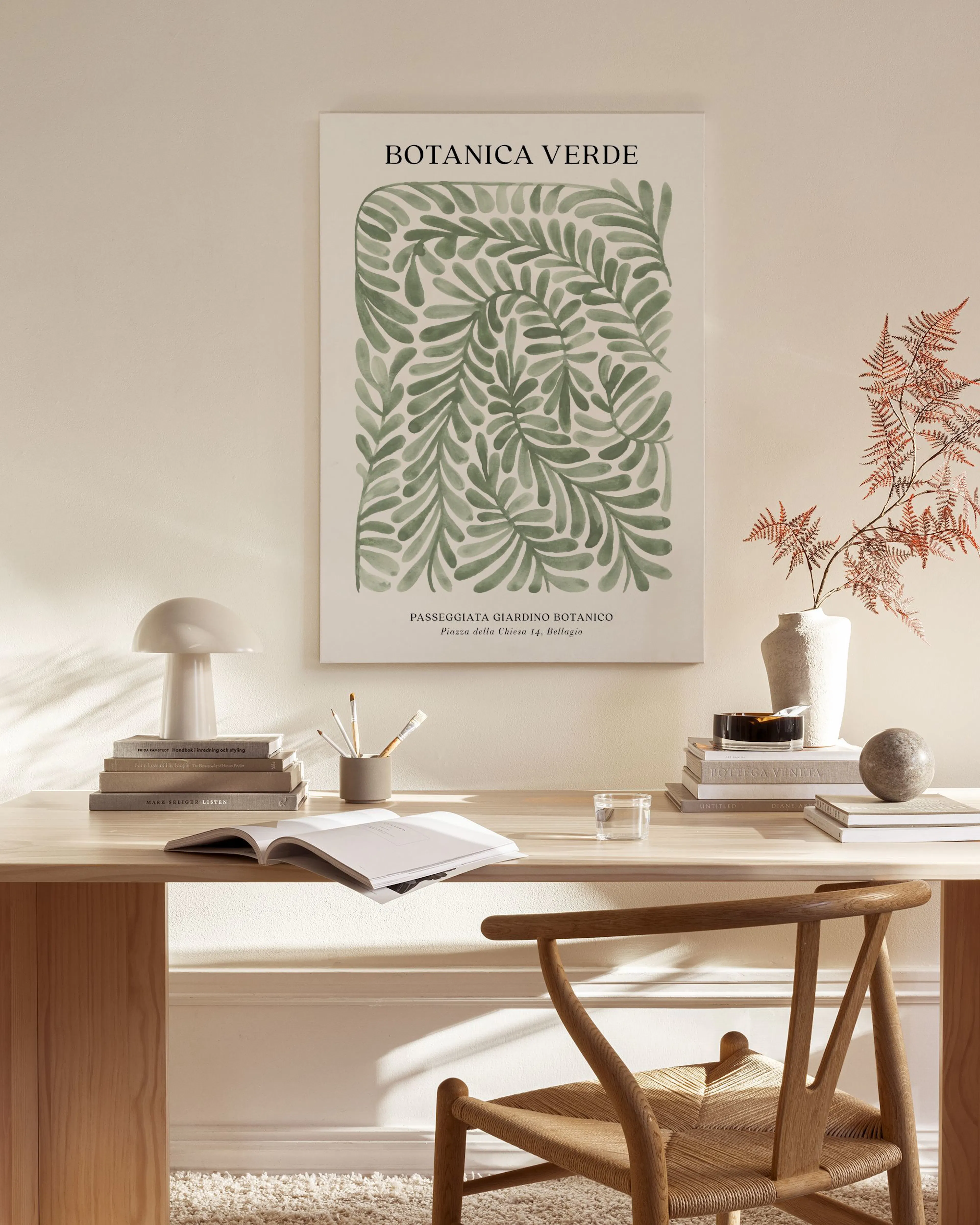 Canvas met groene bladeren en BOTANICA VERDE, hangend in een lichte woonkamer boven een houten dressoir.