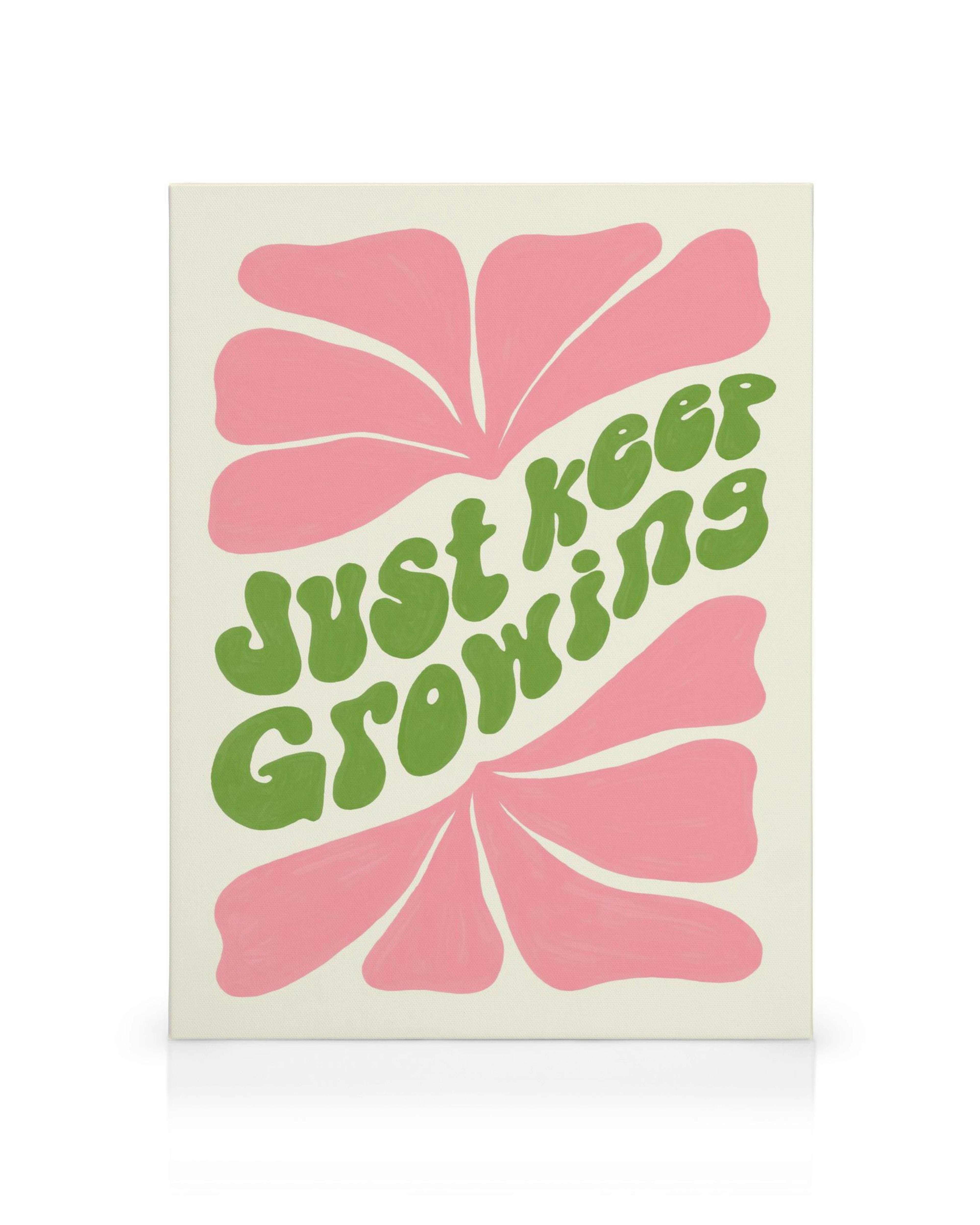 Leinwand mit rosa Blüten und grünem Schriftzug just keep growing in Retro-Schriftart.
