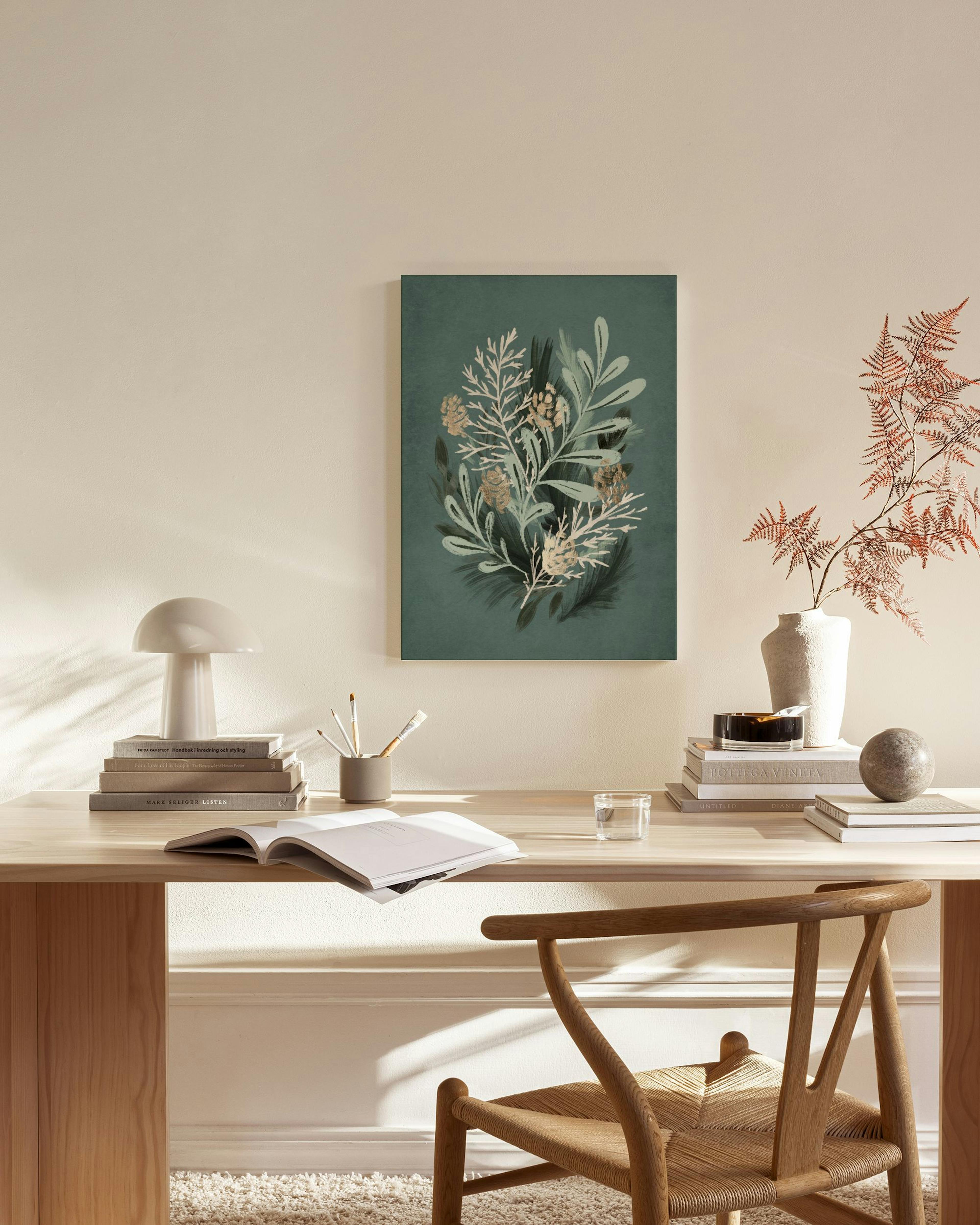 Tela decorativa de um bouquet botânico em tons de verde, bege e cinzento, pendurada numa sala de estar minimalista.