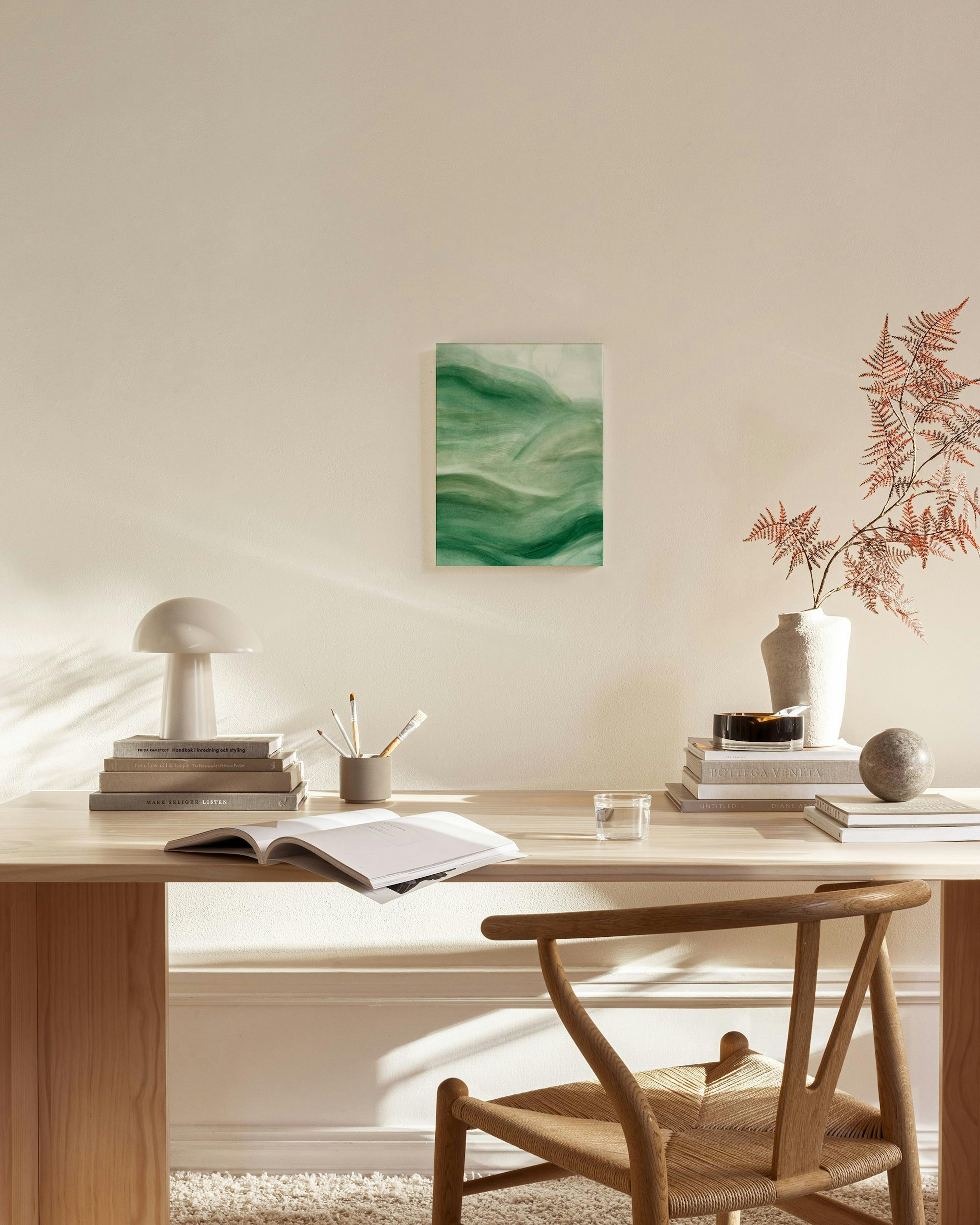 Toile aux formes organiques vertes, suspendue au-dessus dun banc en bois clair dans un salon moderne.