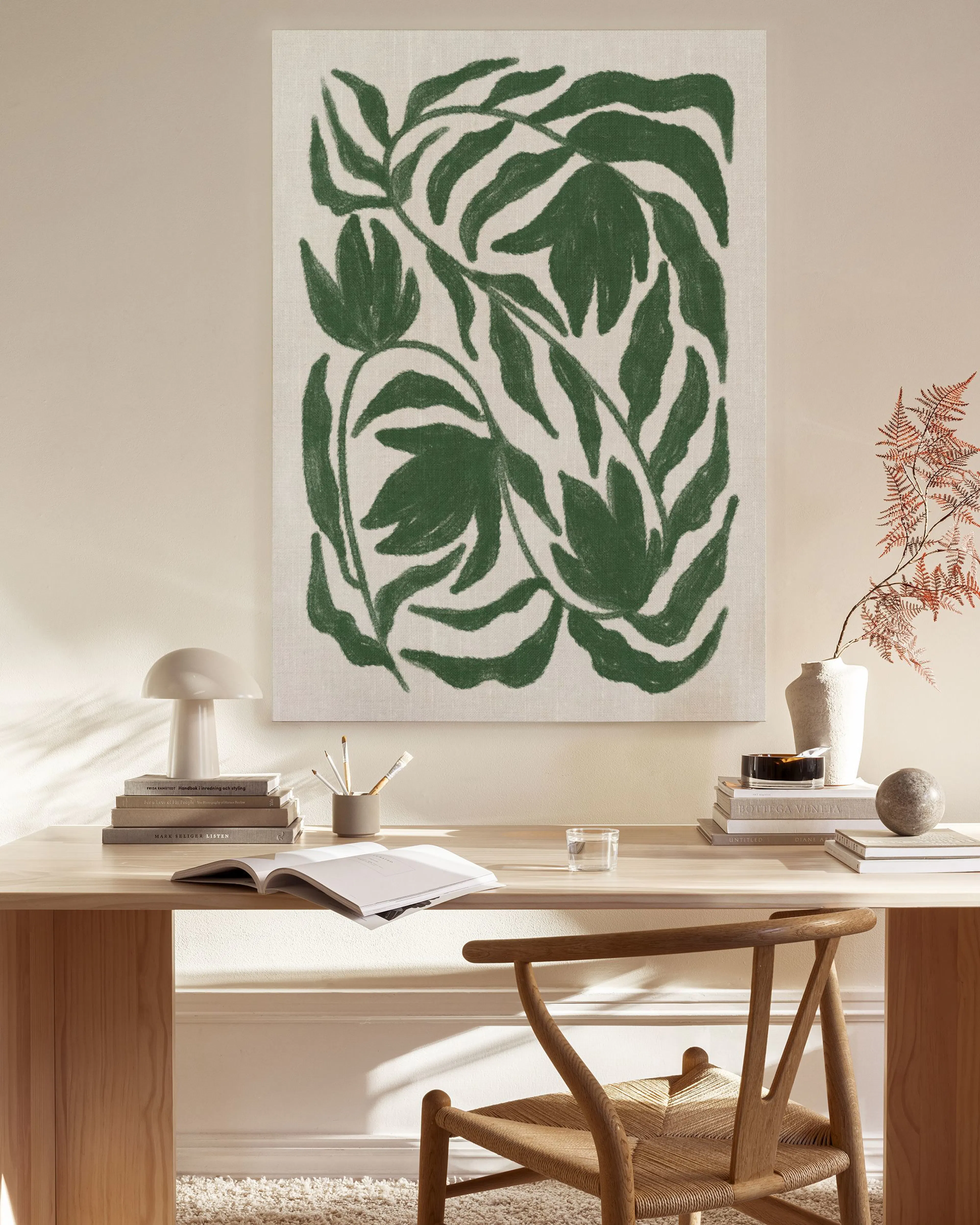 Toile murale abstraite de feuilles vertes sur fond clair, affichée au-dessus dun banc en bois dans un salon moderne.