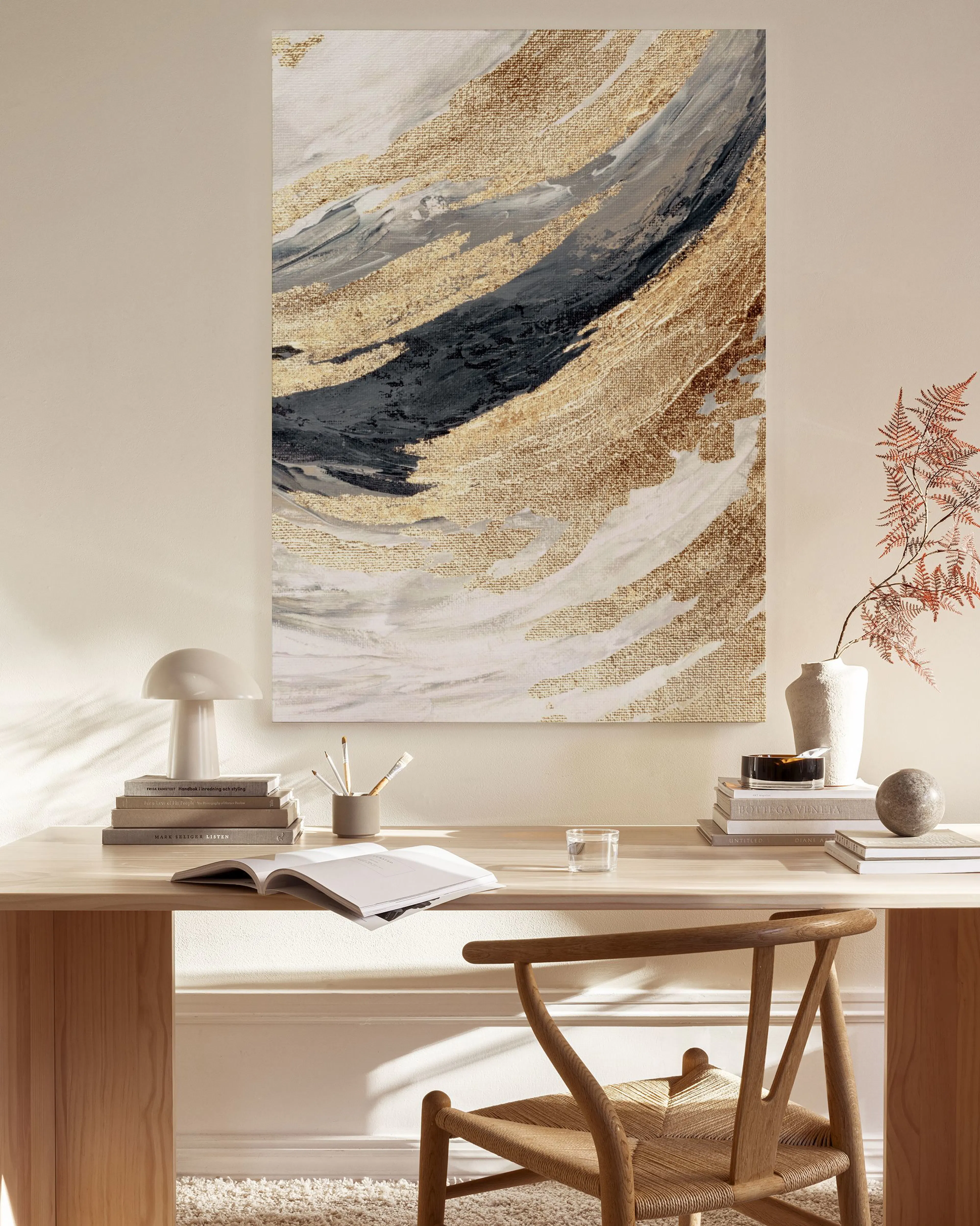 Toile abstraite aux formes fluides or et noir, suspendue dans un salon lumineux au-dessus dun banc en bois clair.