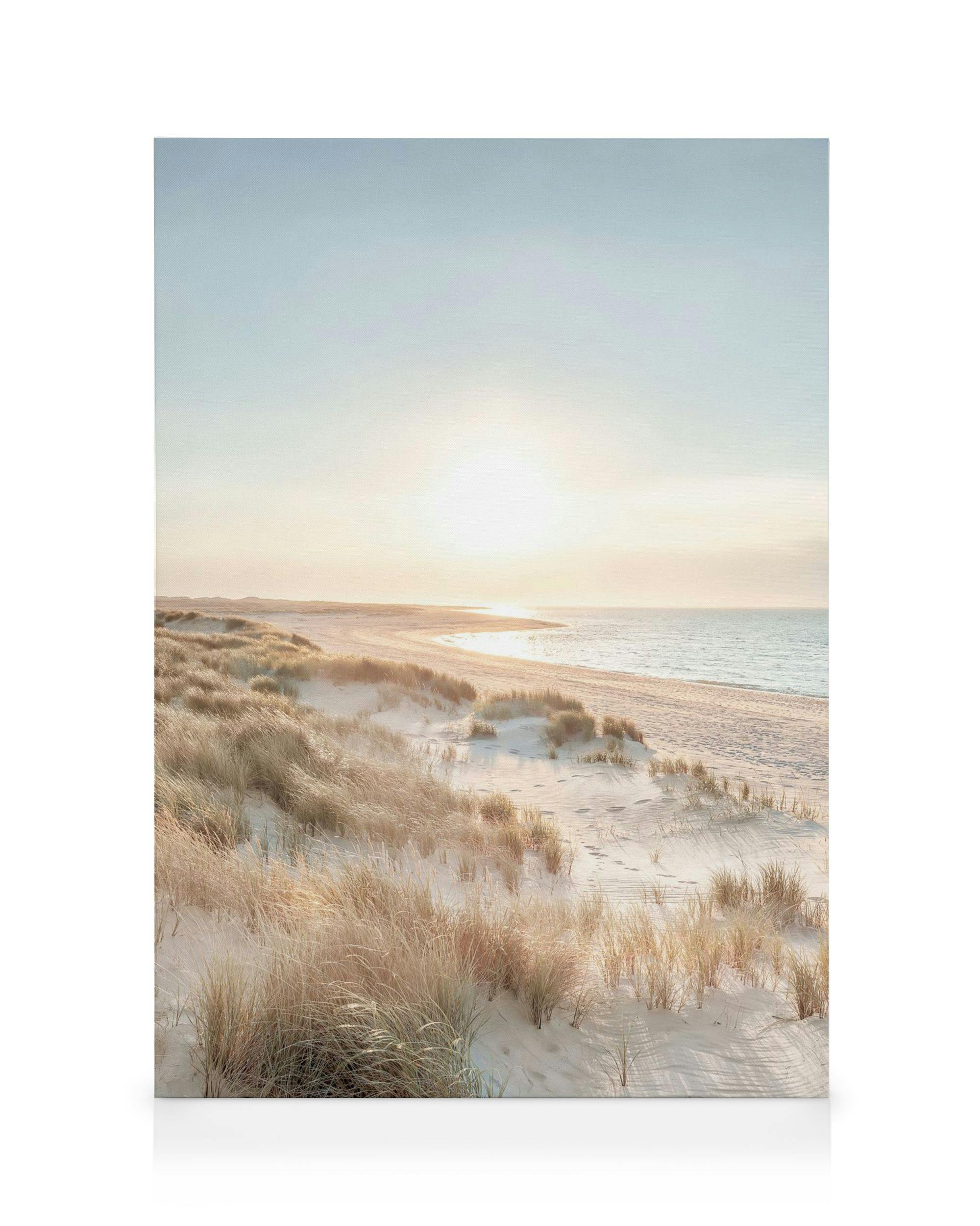 Canvas print of a peaceful beach with sand dunes, sunrise, and calm sea in soft blues, yellows, and white.