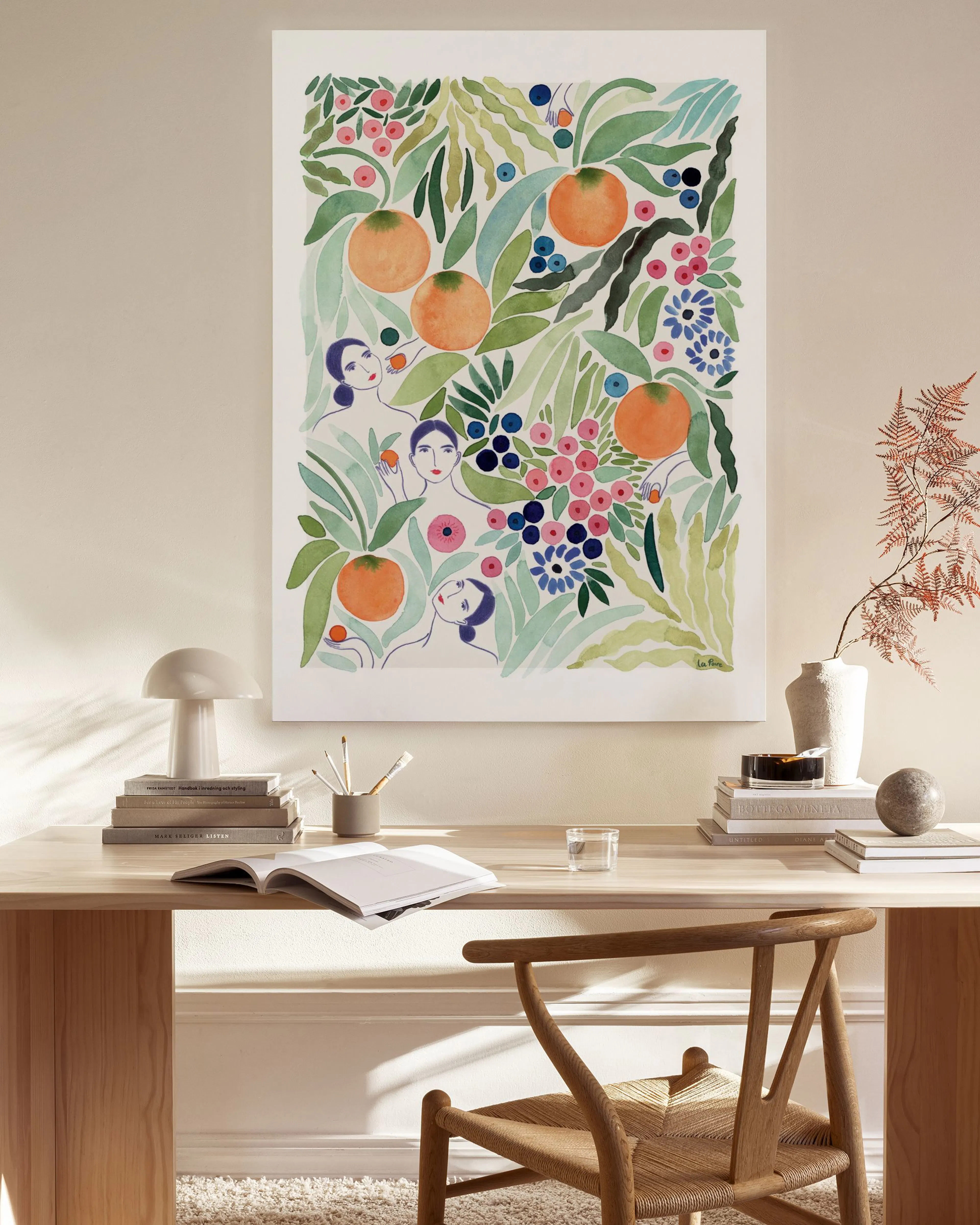 Lærred med illustrerede appelsiner, bær, blomster og kvindeansigter i et lyst, moderne rum.